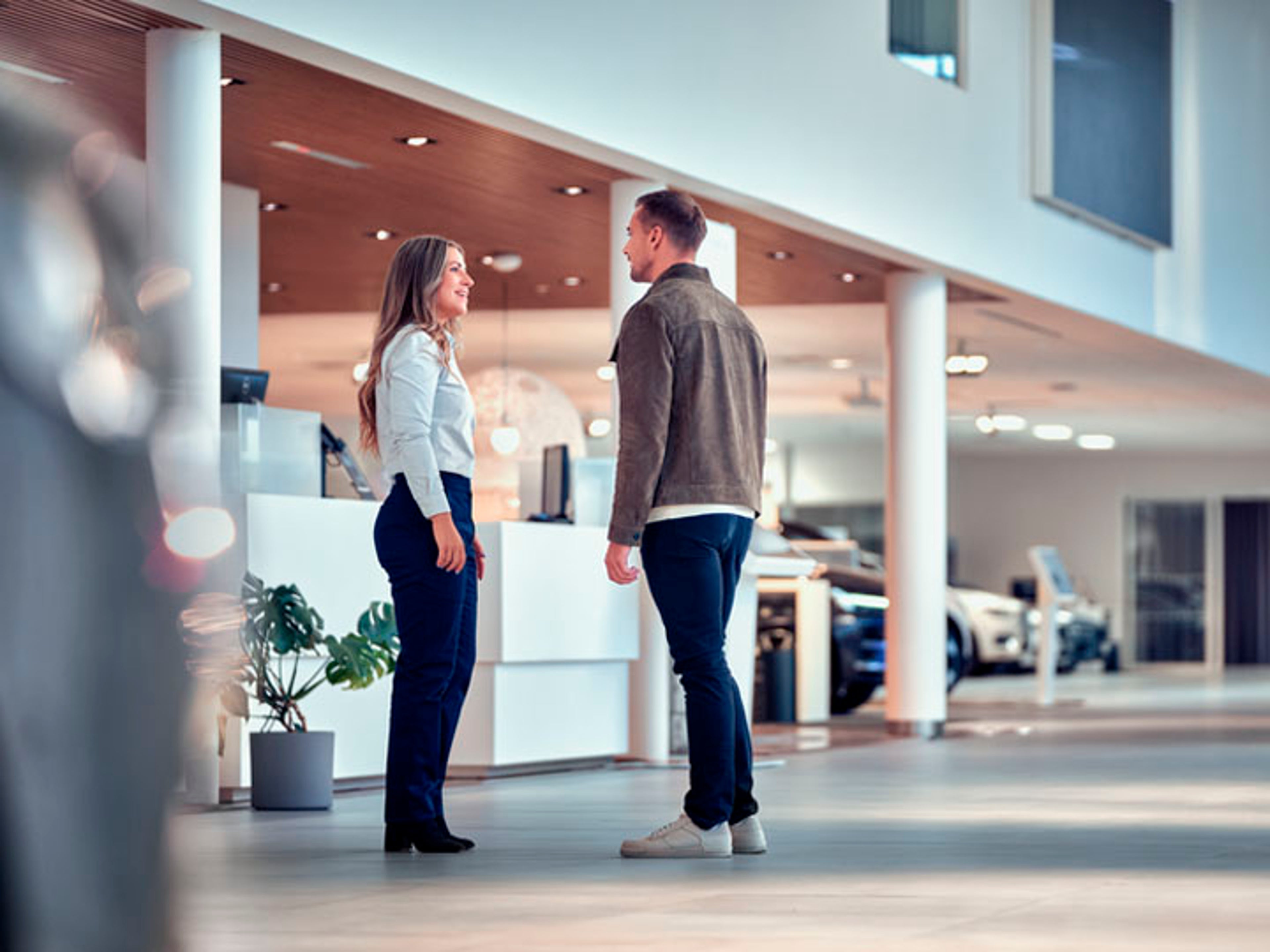 Un hombre y una mujer charlando en un servicio oficial Volvo