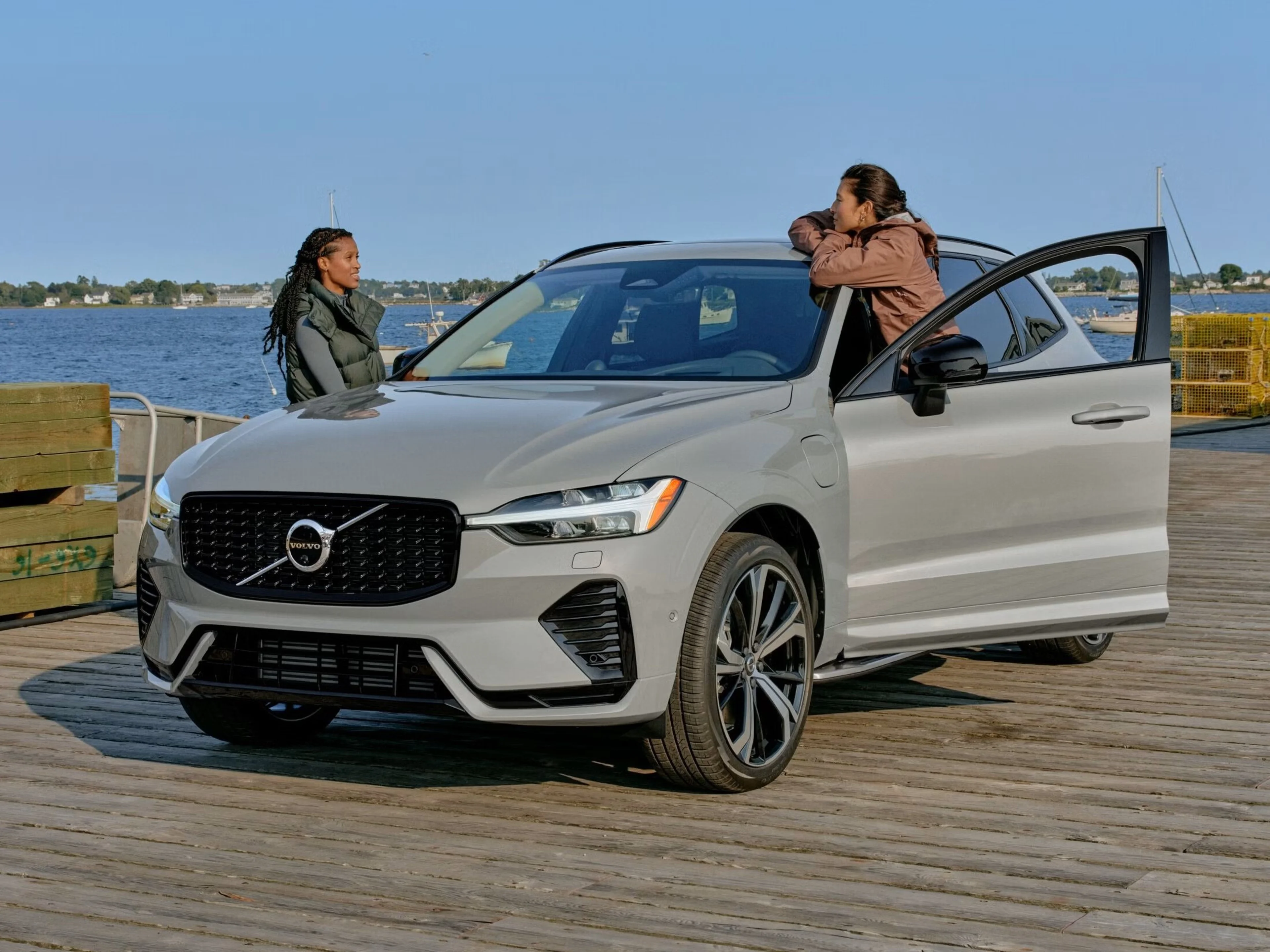 Two people speaking to each other near a Volvo XC60