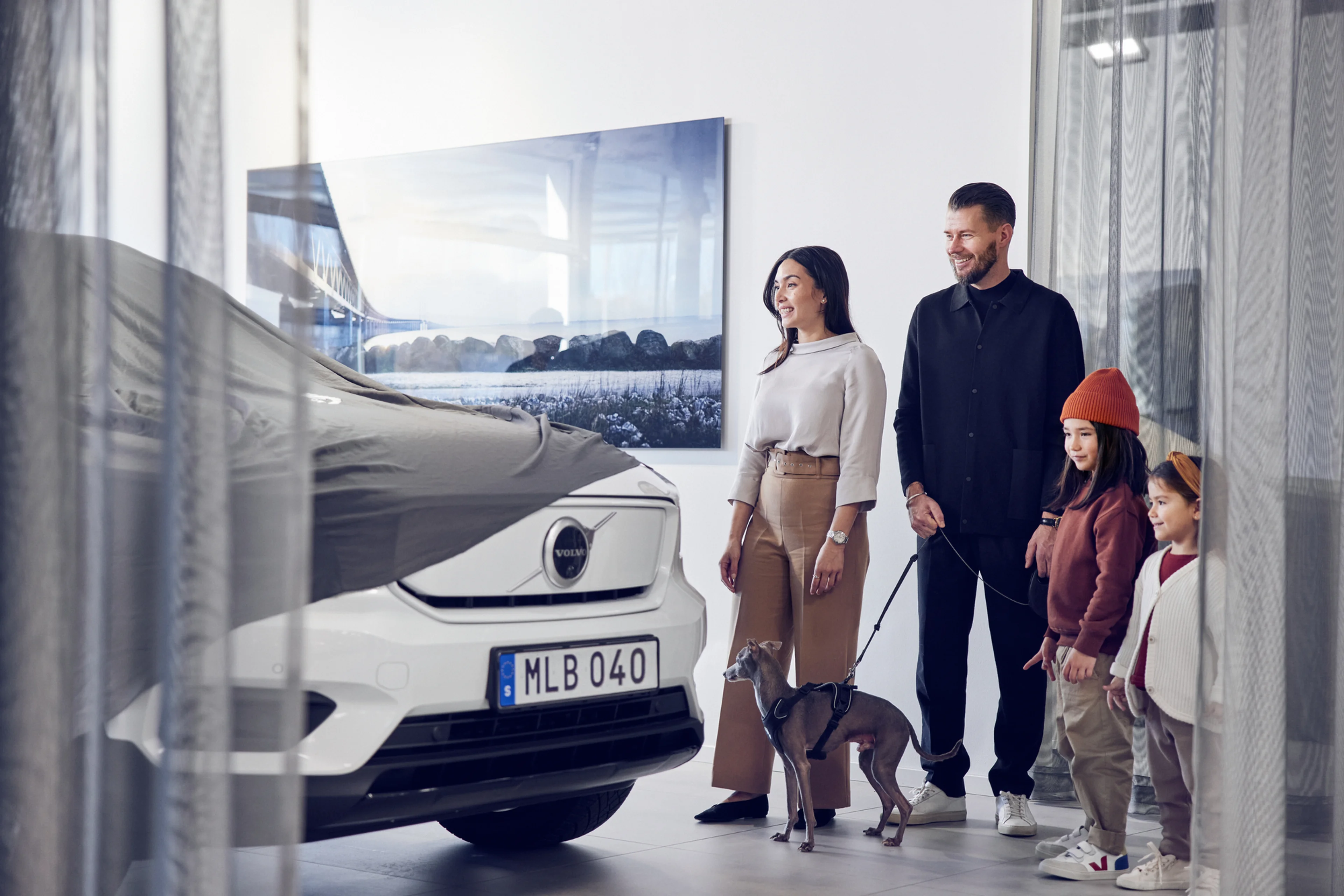 familie met hond bekijken hun Volvo