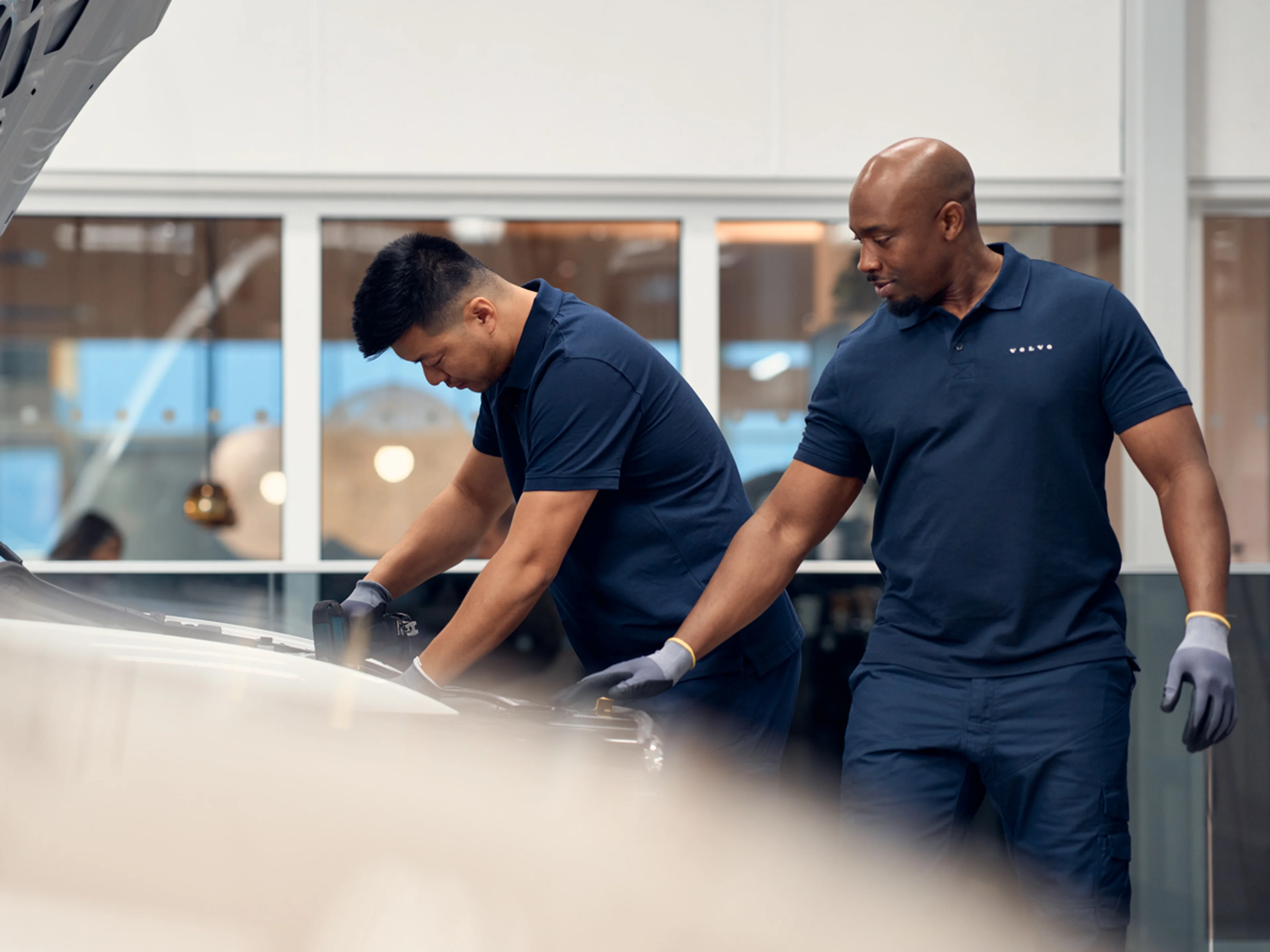 Volvo servicetekniker skakar hand med kund framför en Volvo XC60.