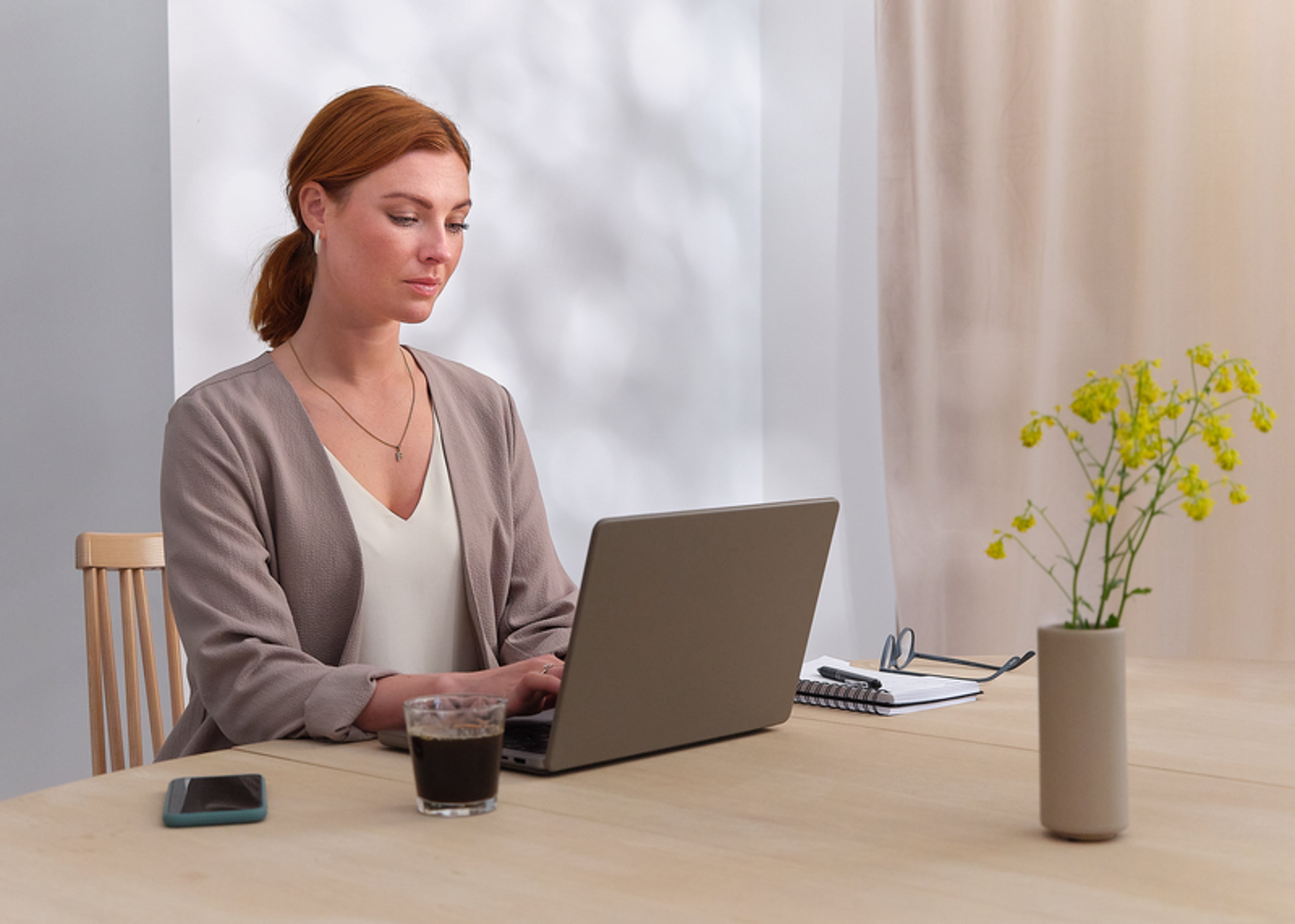 Kobieta siedząca przy biurku z laptopem