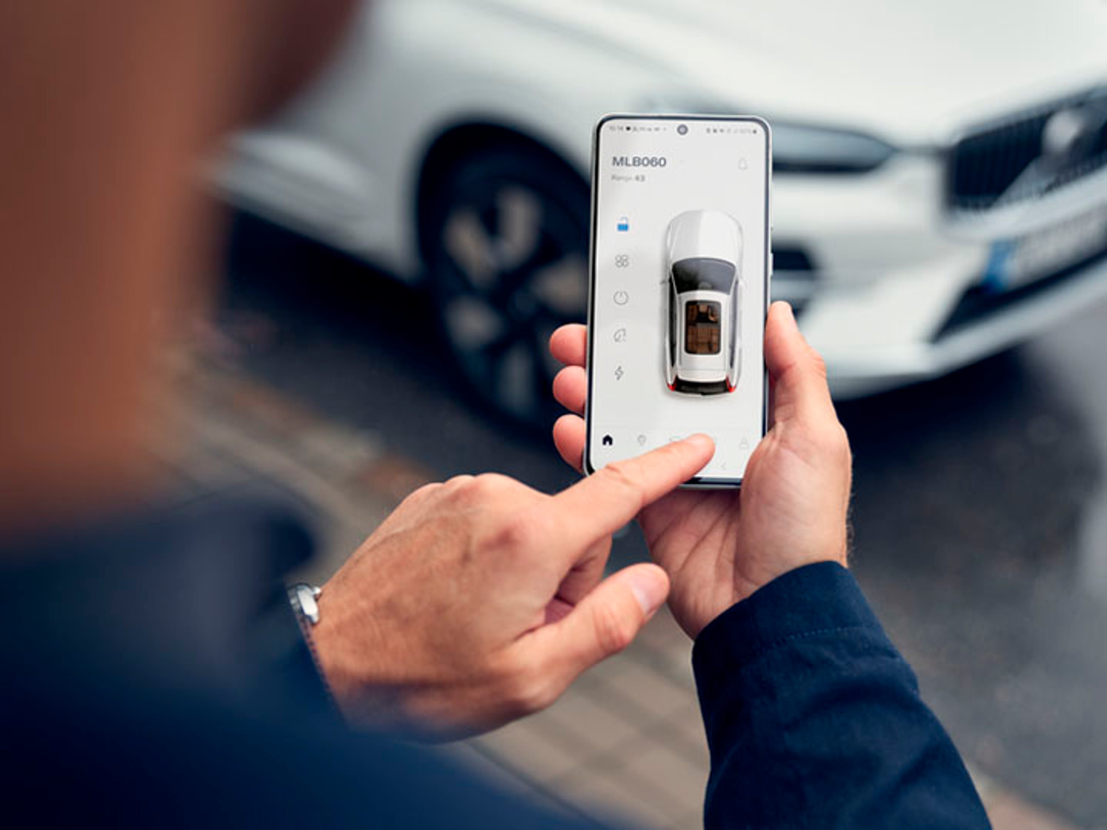 Una persona sujetando un móvil con la Aplicación Volvo Cars abierta