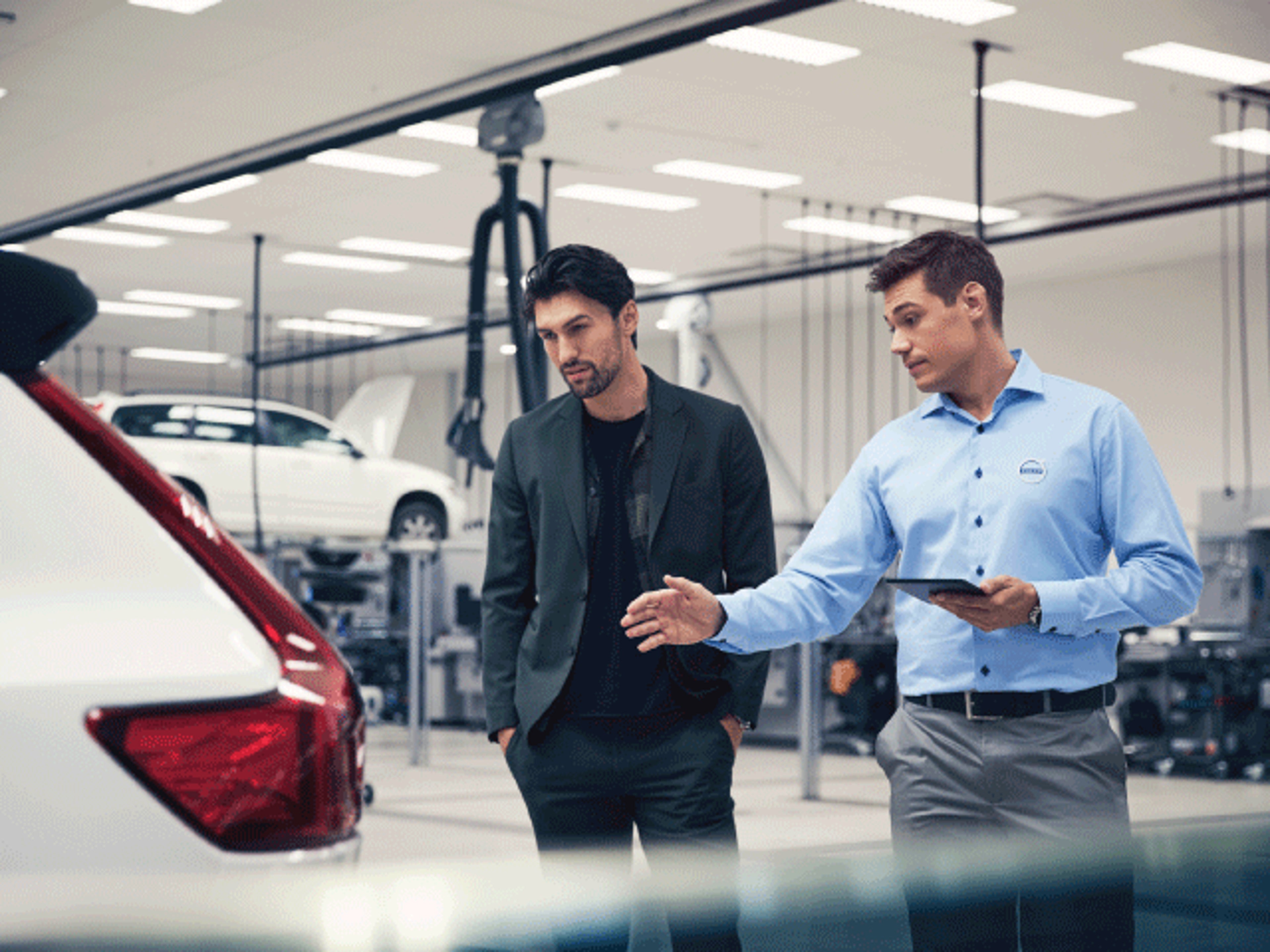 A man explaining about car to another