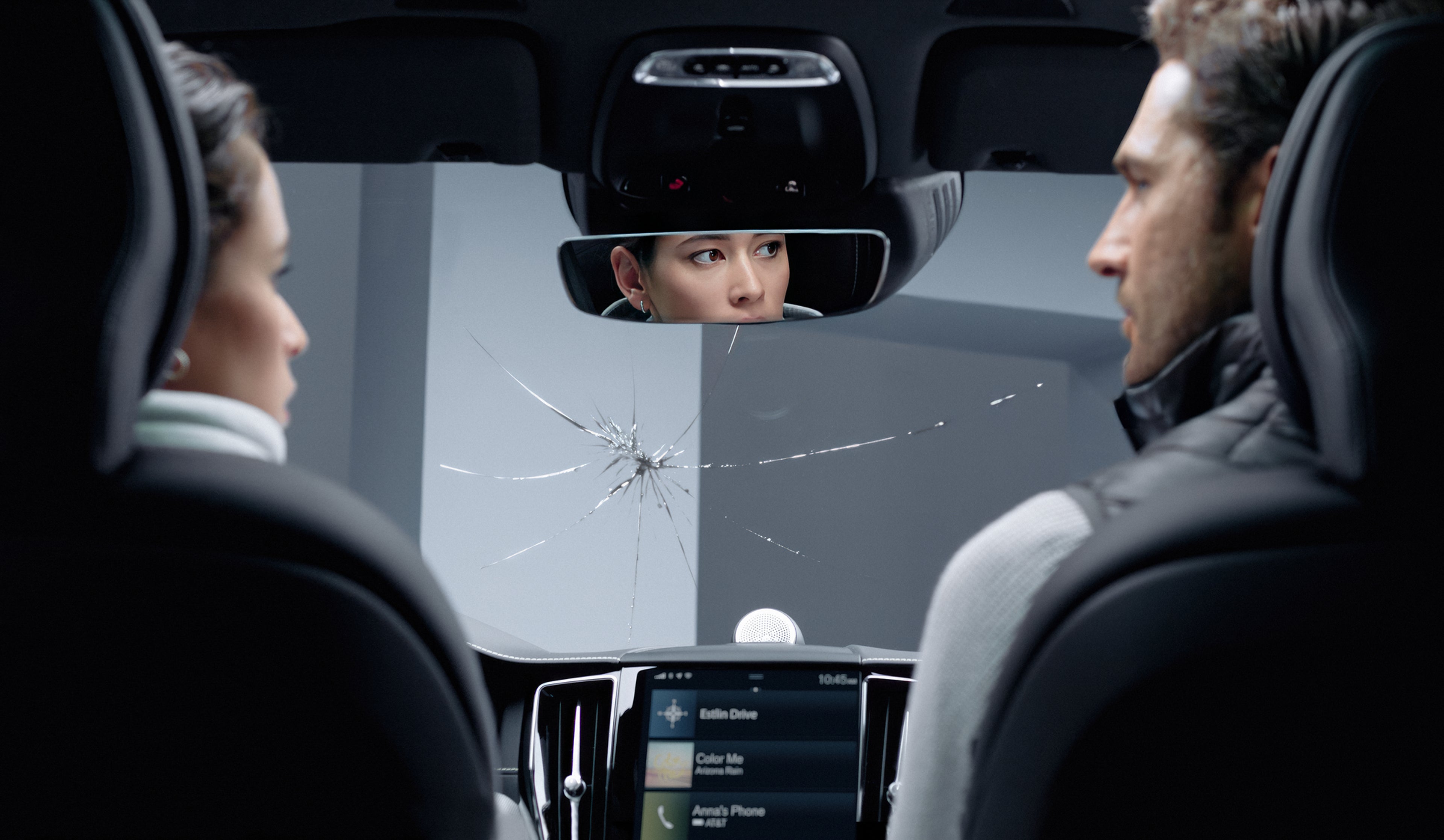 pár sediaci v aute ktoré má prasknuté čelné sklo