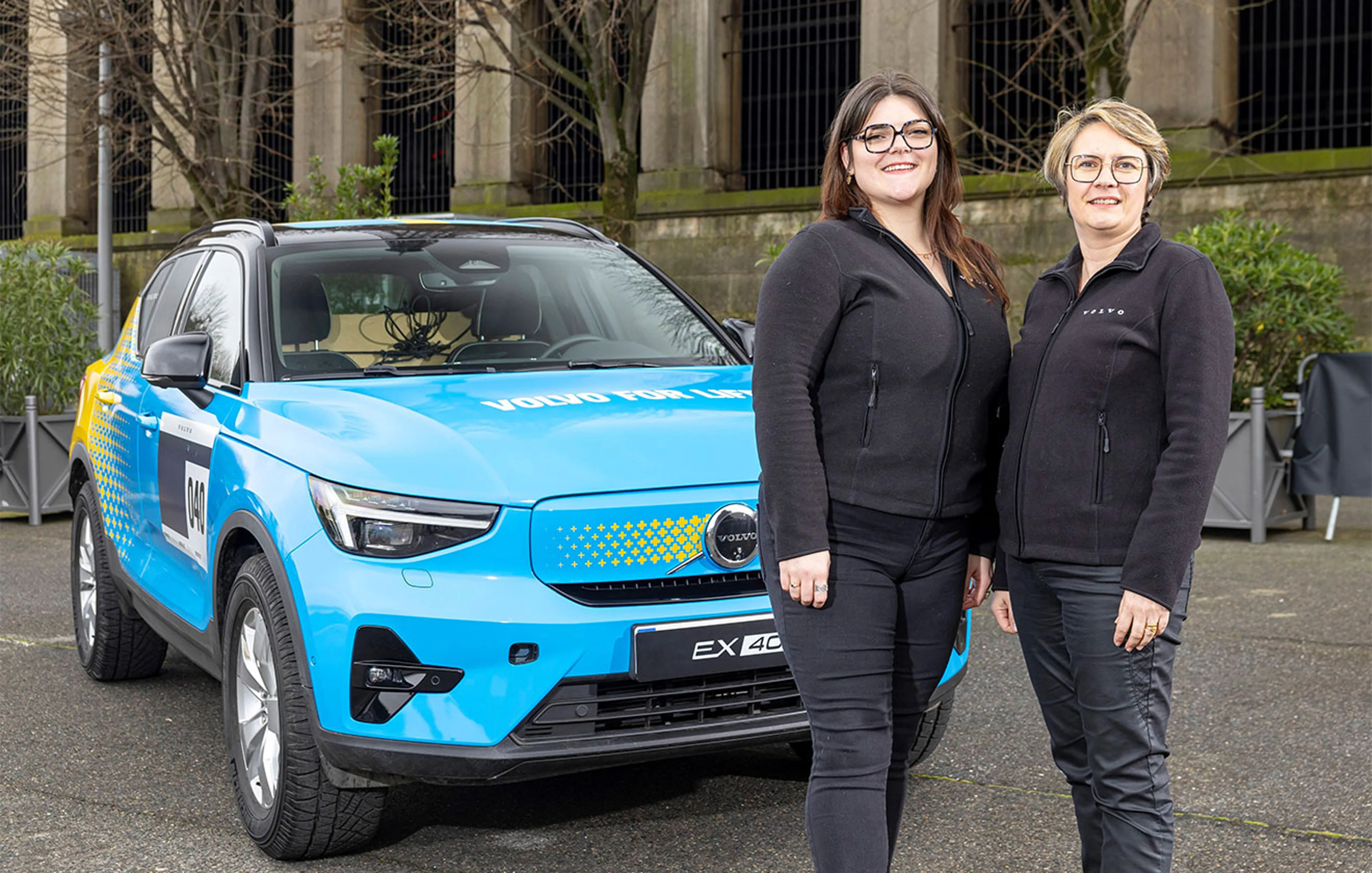 Marie Brabant et Séverine Mary devant une Volvo EX40 bleue avec "Volvo For Life" sur le capot