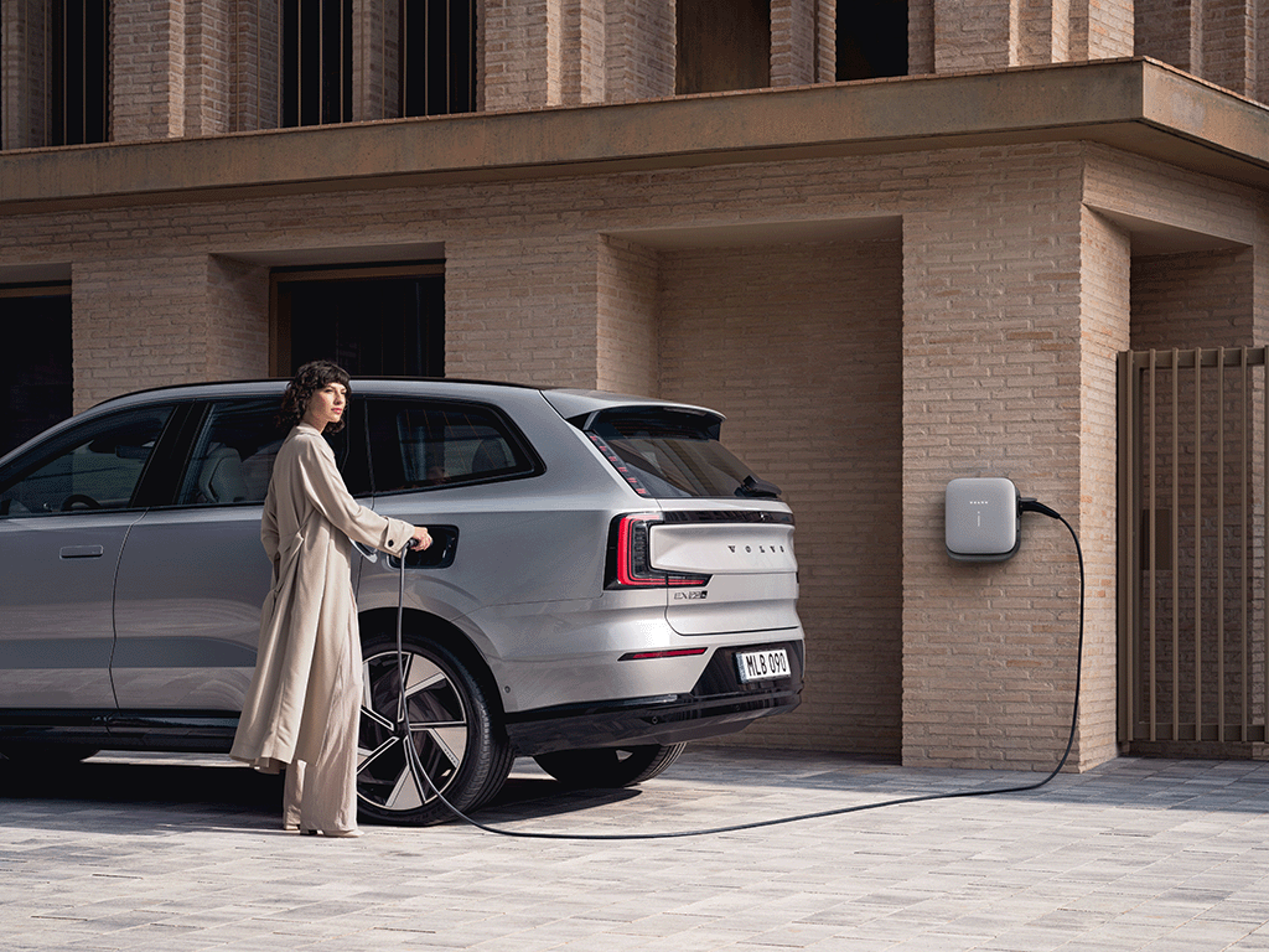 Eine Frau lädt einen Volvo EX90.