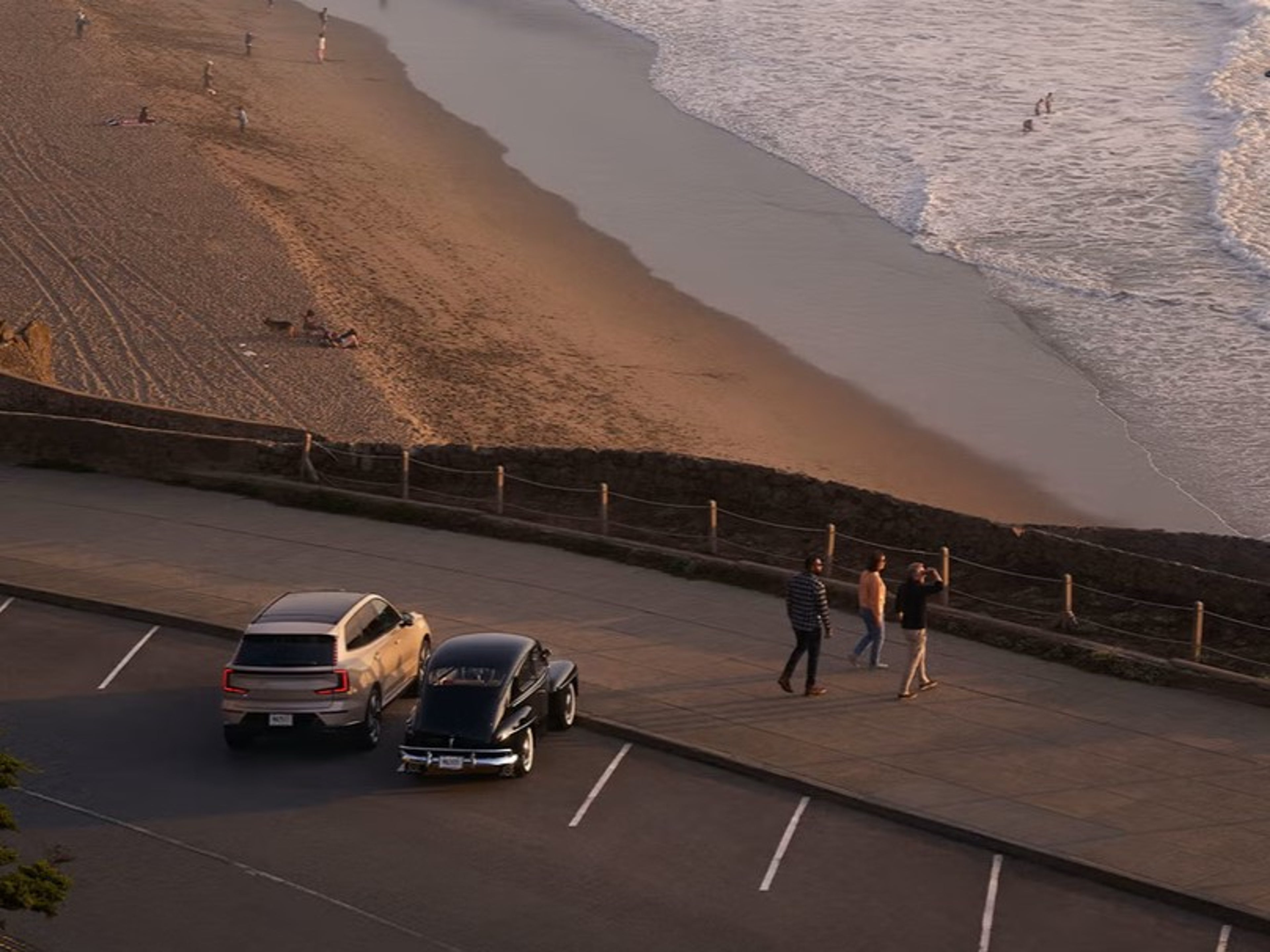 Volvo EX90 next to classic Volvo overlooking beach