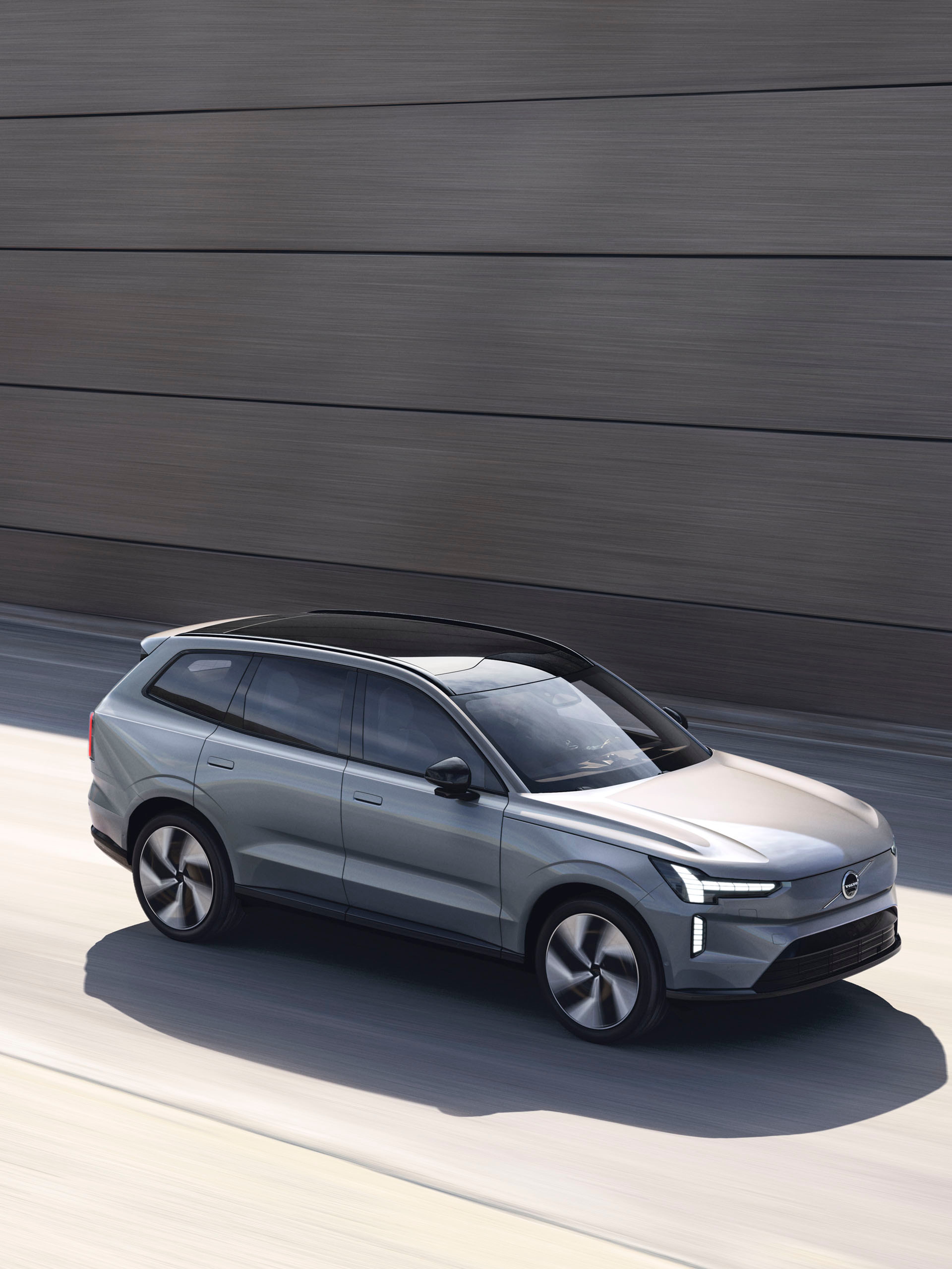 Volvo EX90 eléctrico por una autopista destacando su techo panorámico y sus luces LED