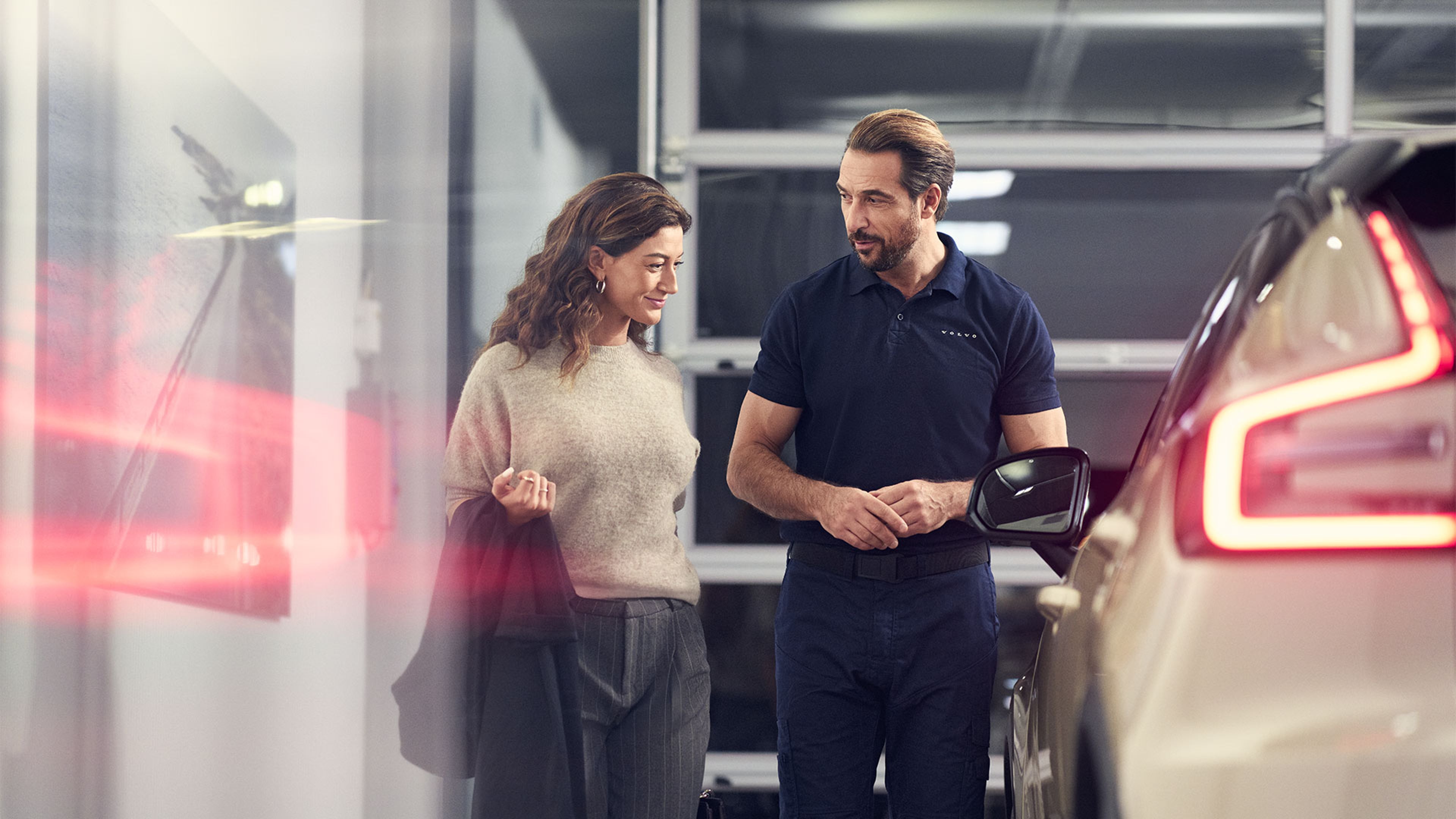 Dans un atelier Volvo, un technicien échange avec une cliente et lui présente le programme Les privilèges V+