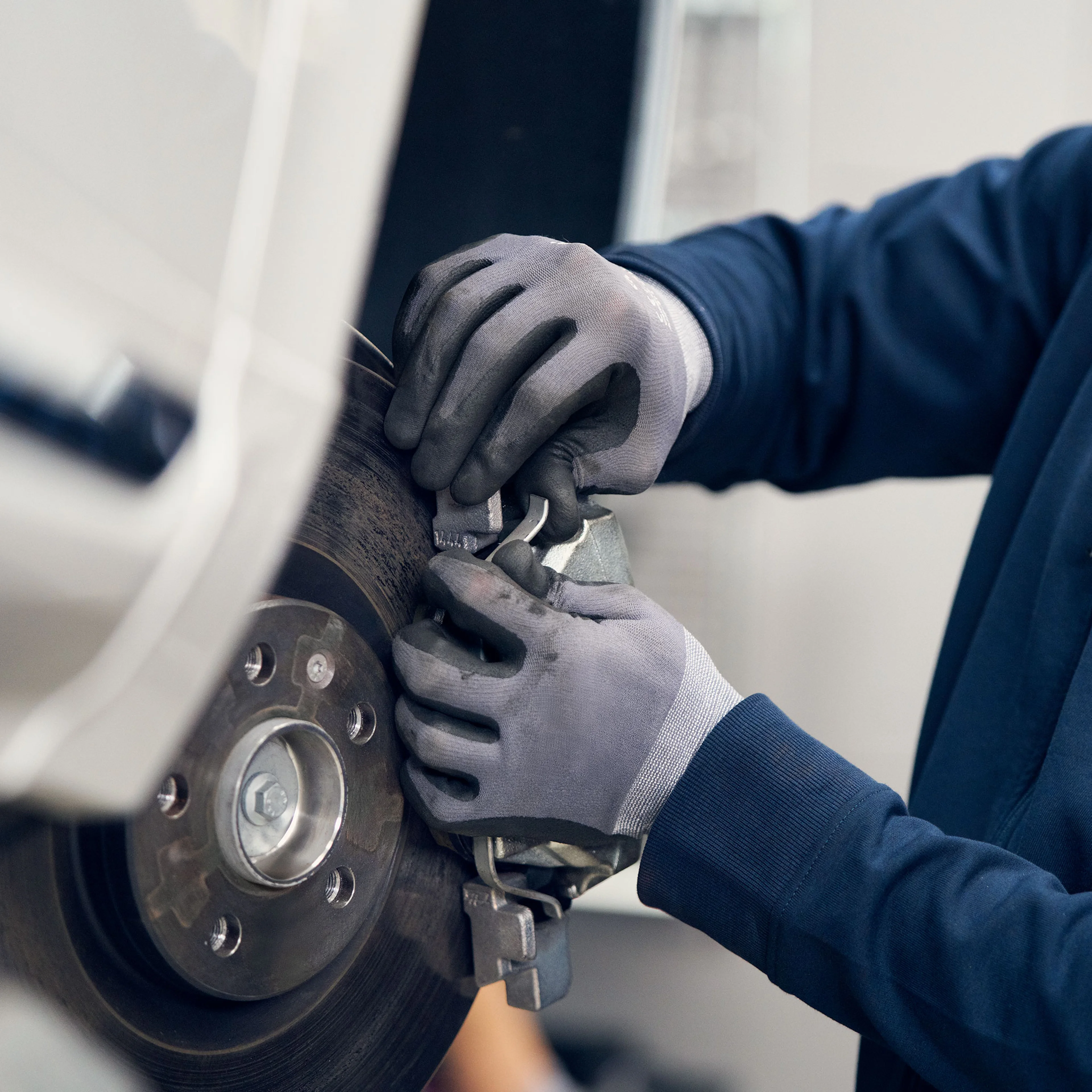 Volvo Omamekaanikko työstää aautoon kiinnitettyjä jarrupaloja.