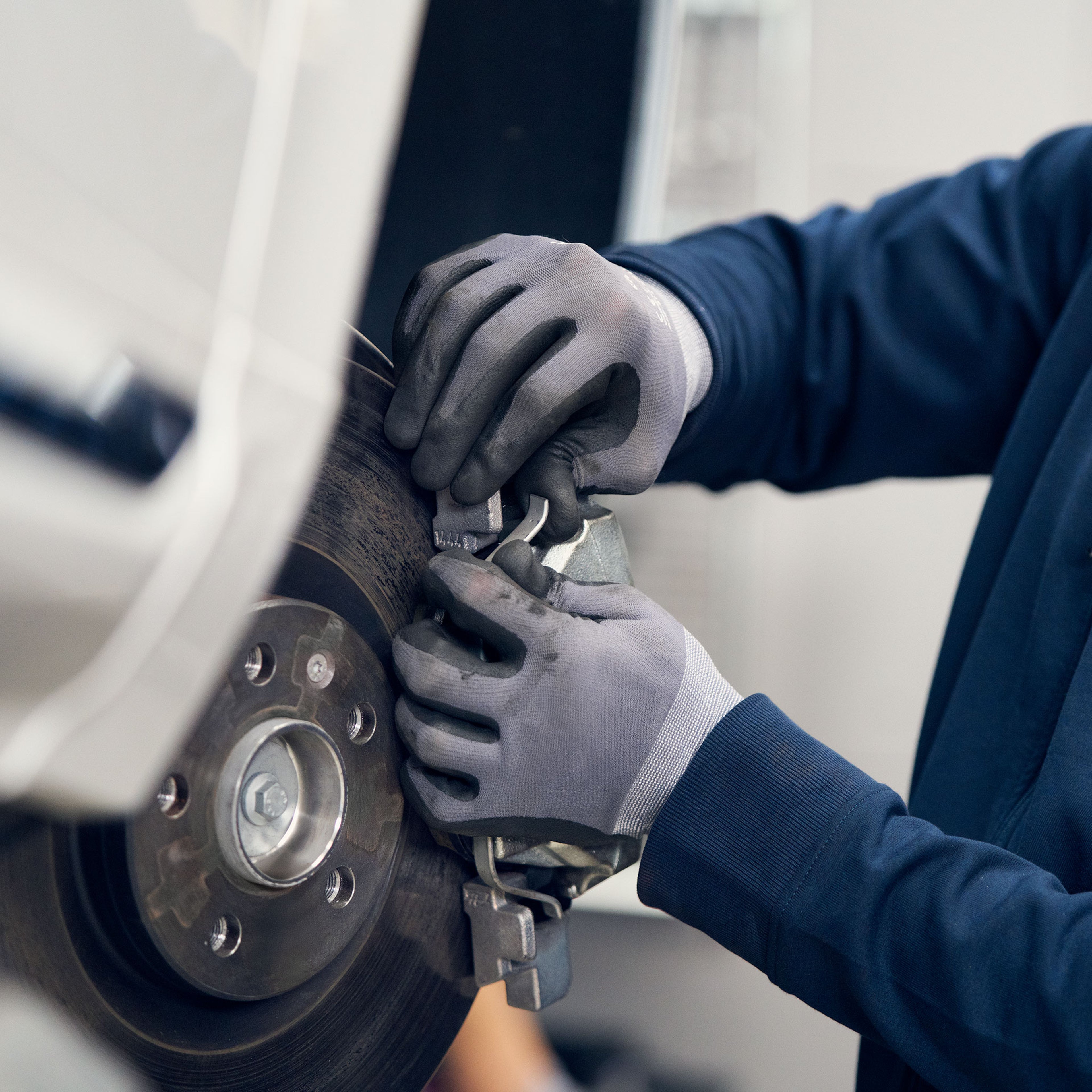 Volvo Omamekaanikko työstää aautoon kiinnitettyjä jarrupaloja.