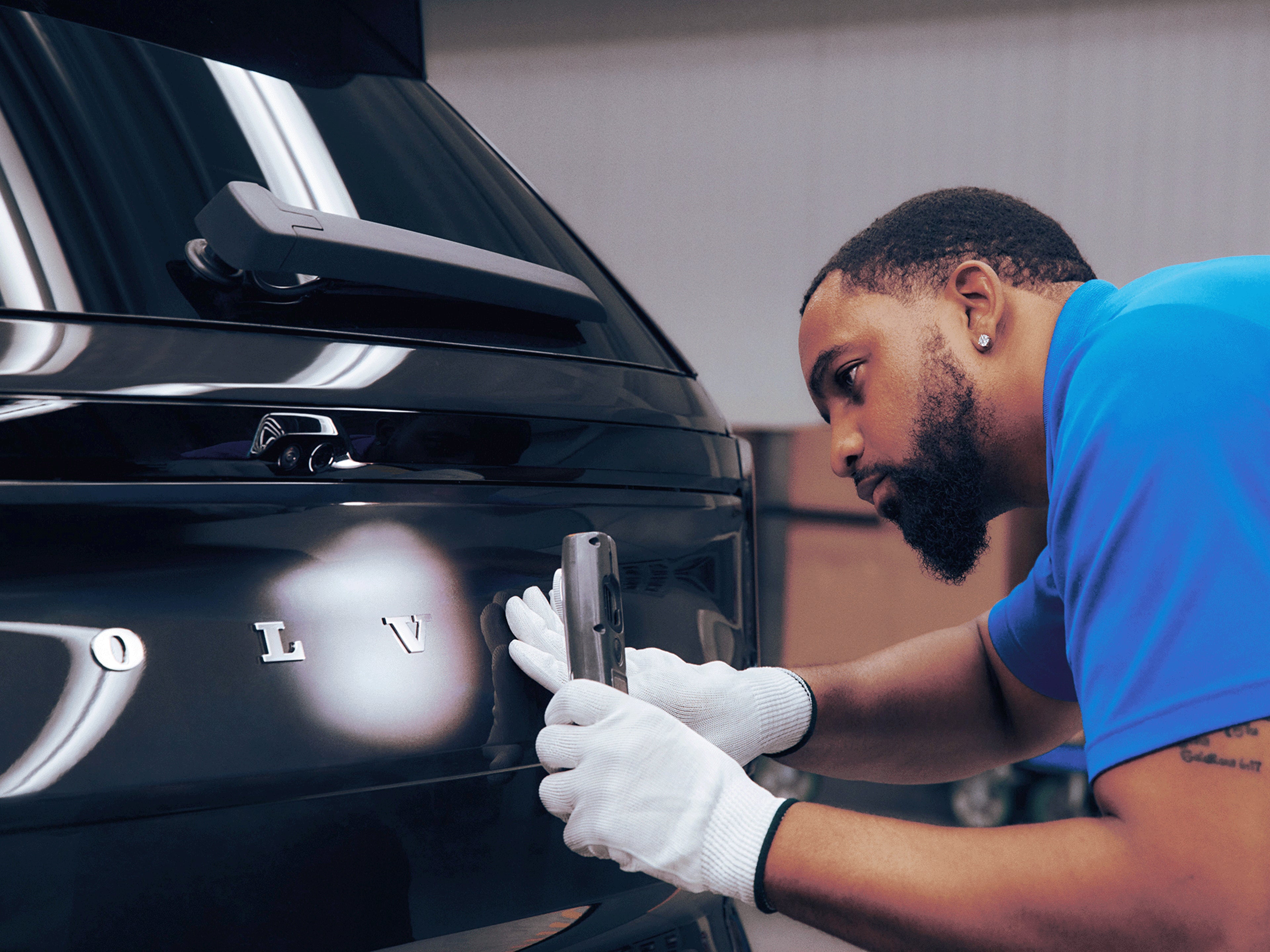 Ein Volvo Mitarbeiter bei den finalen Arbeiten an einem Volvo EX90.