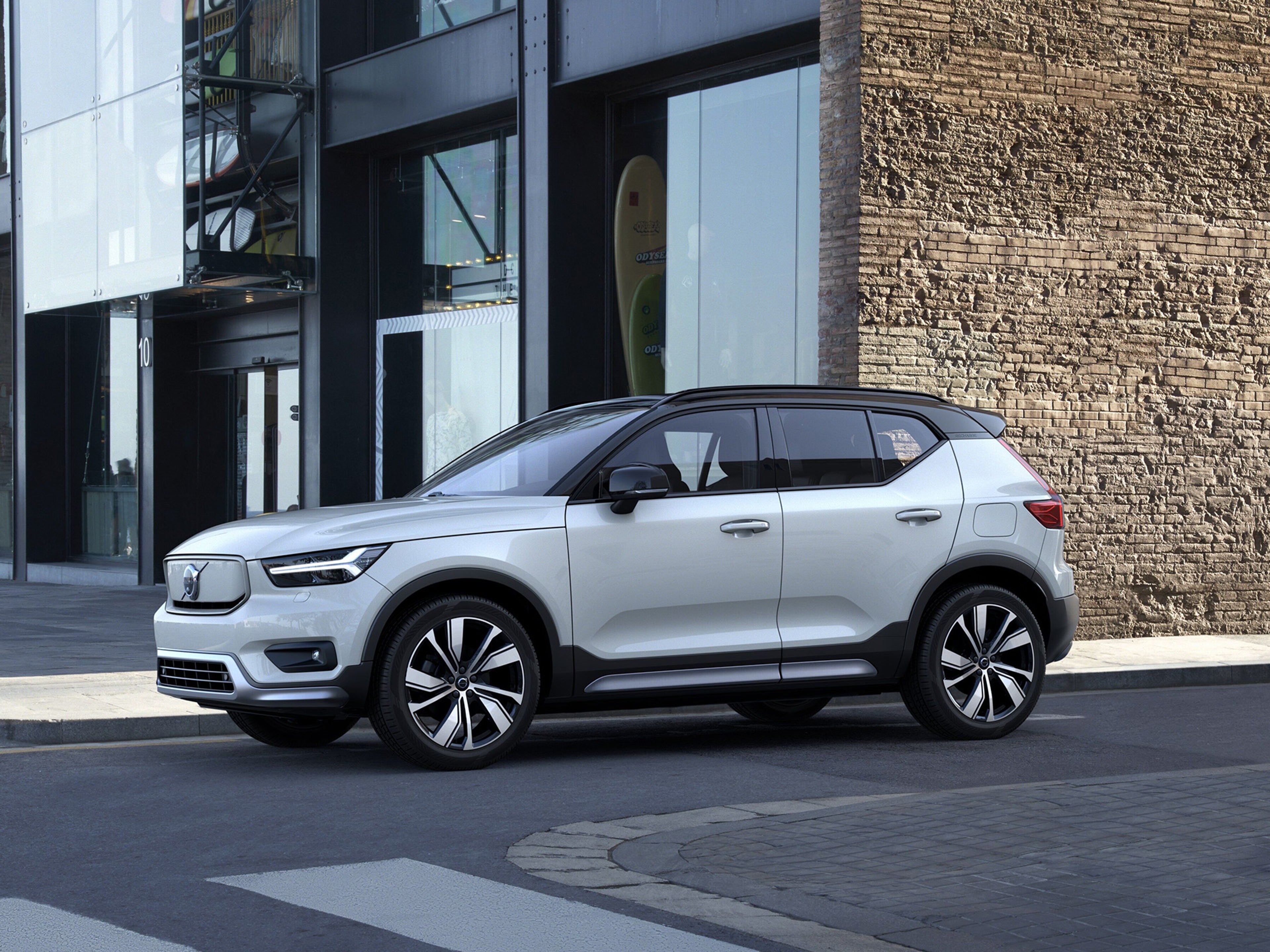 XC40 branco vista lateral numa estrada, com uma parede de pedra