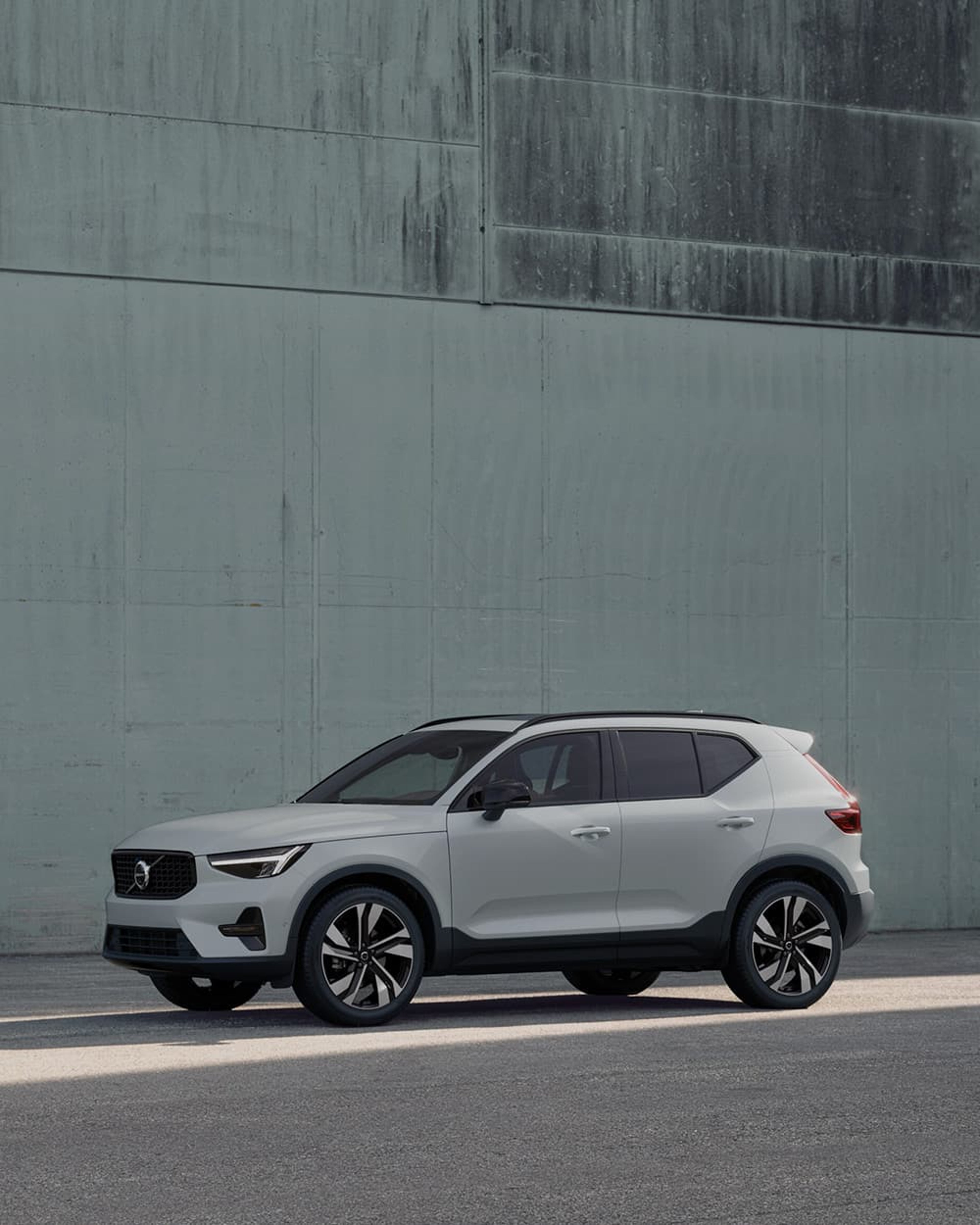 Une Volvo XC40 garée contre un mur vert