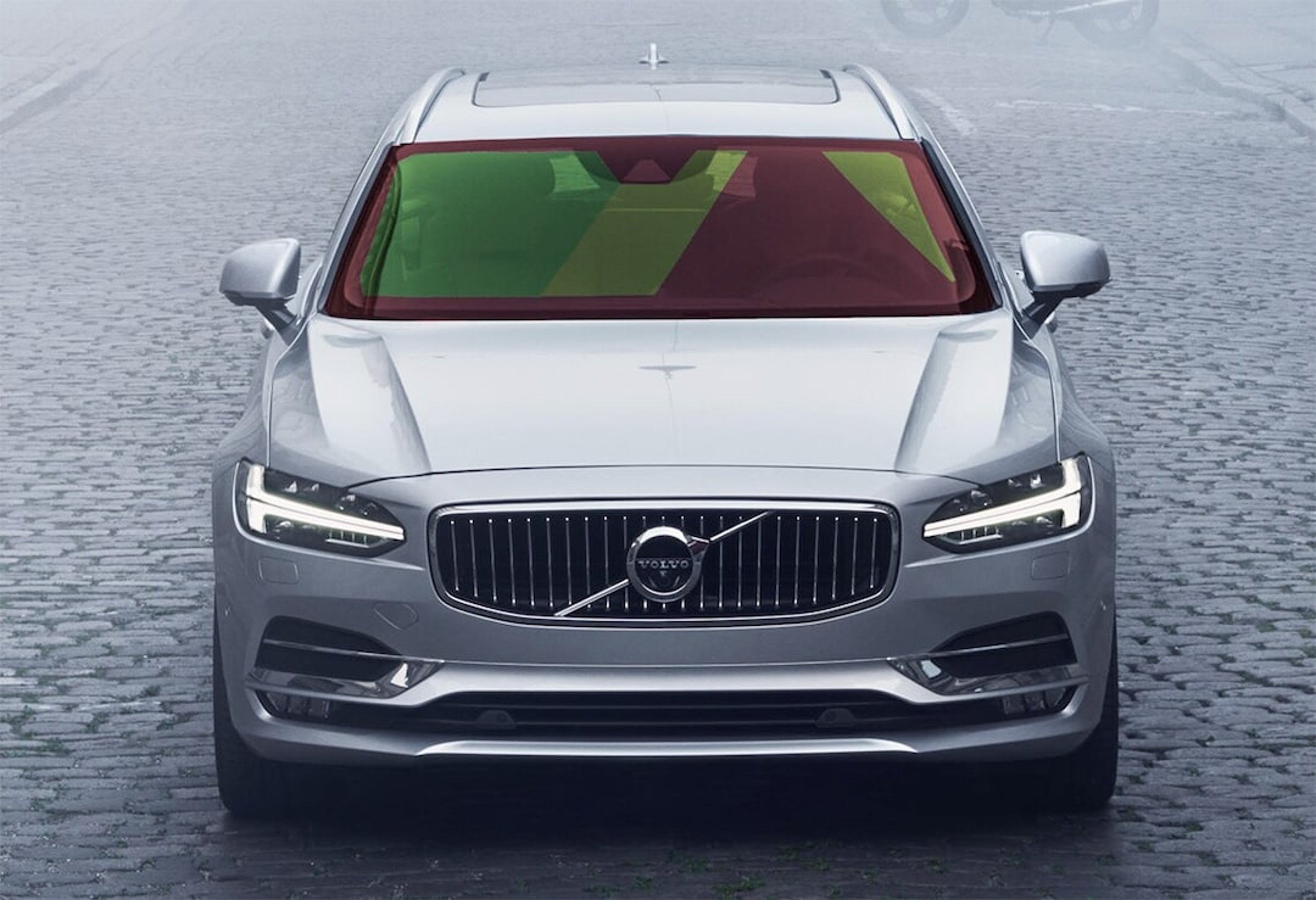 Vue de face d'une Volvo argentée avec une mise en évidence visuelle des capteurs et caméras avancés dans le pare-brise.