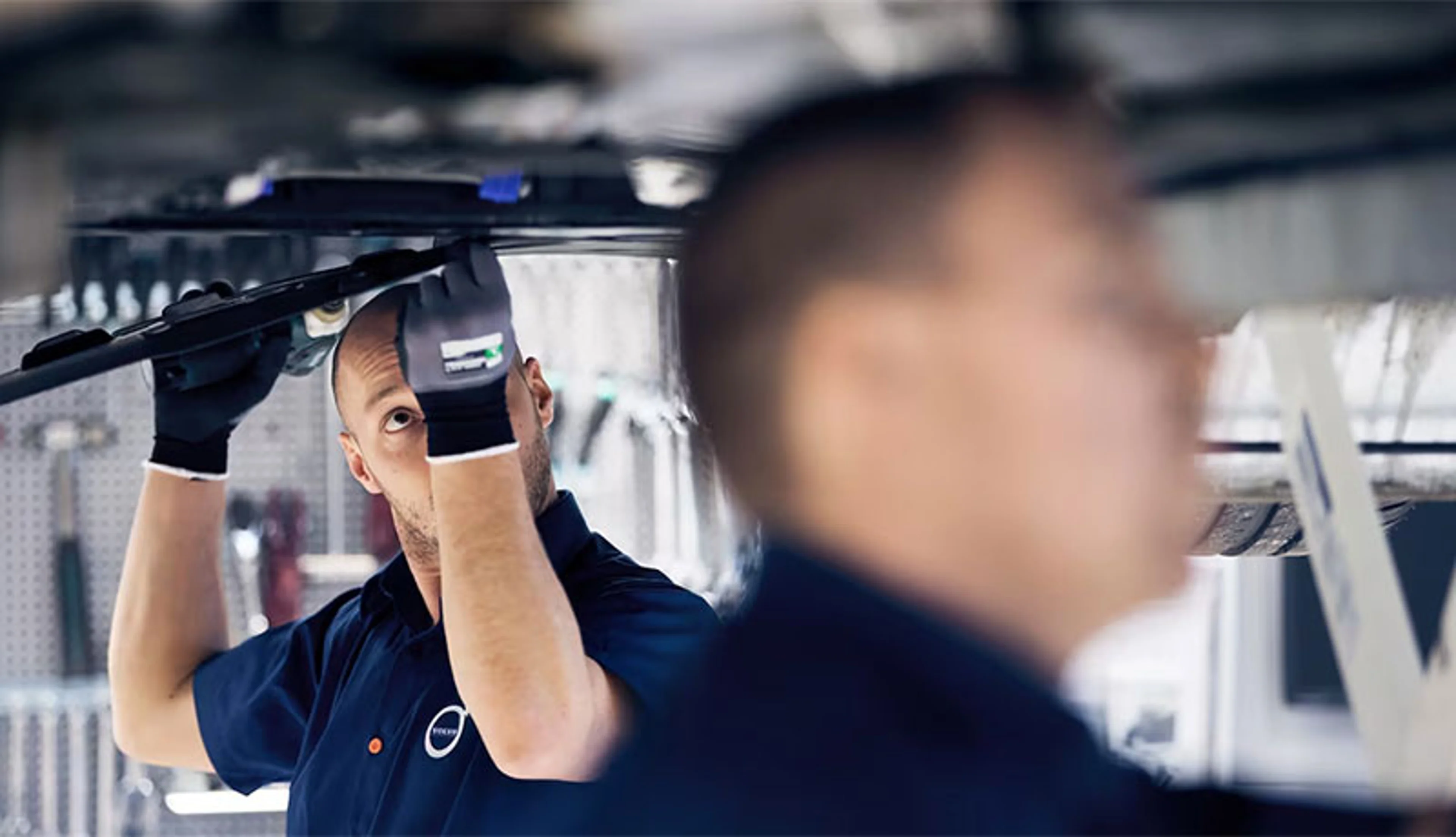 2 hommes entrain de réparer une Volvo