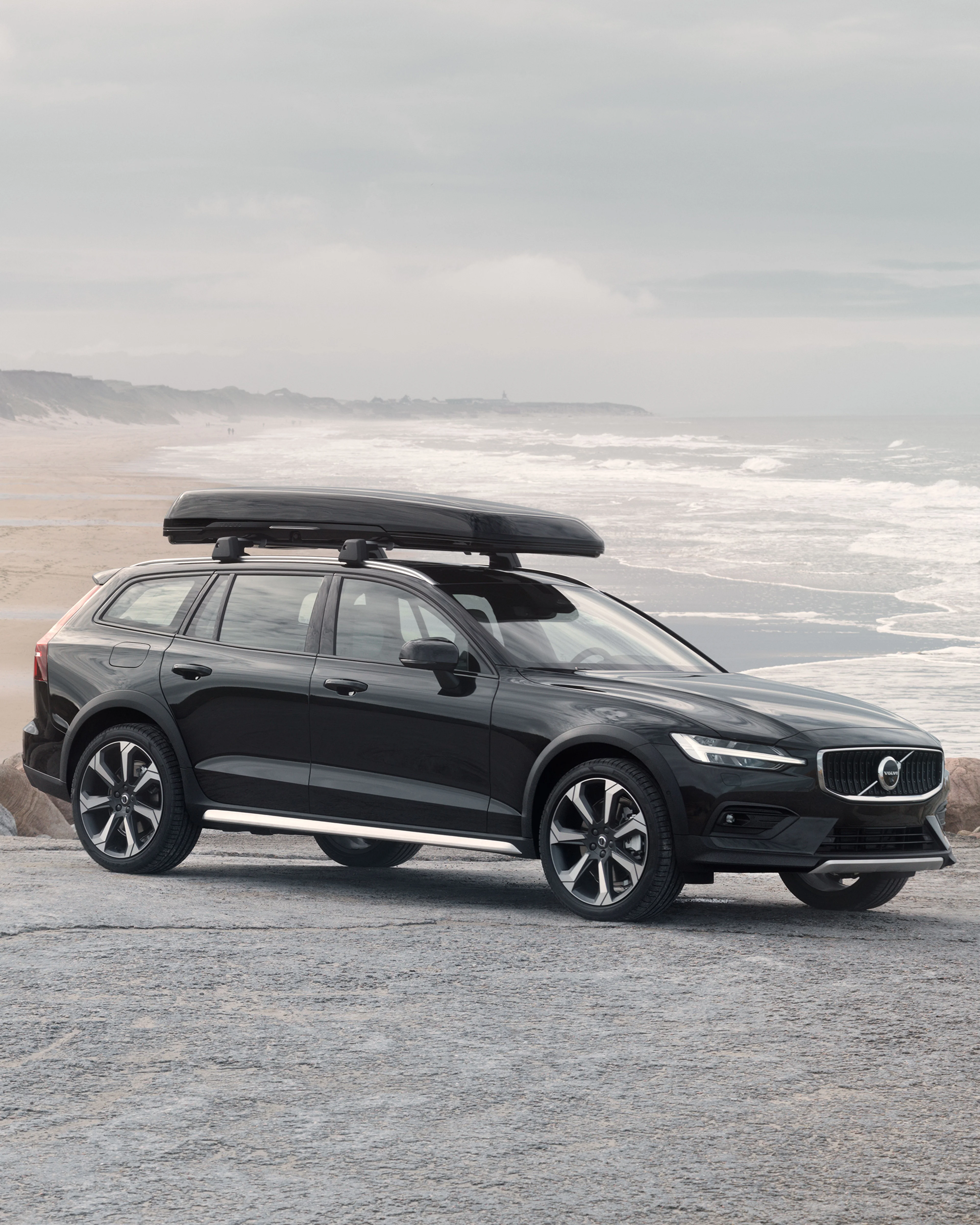 Bild mit einem Volvo V60 Cross Country, der zwischen Sanddünen geparkt ist.