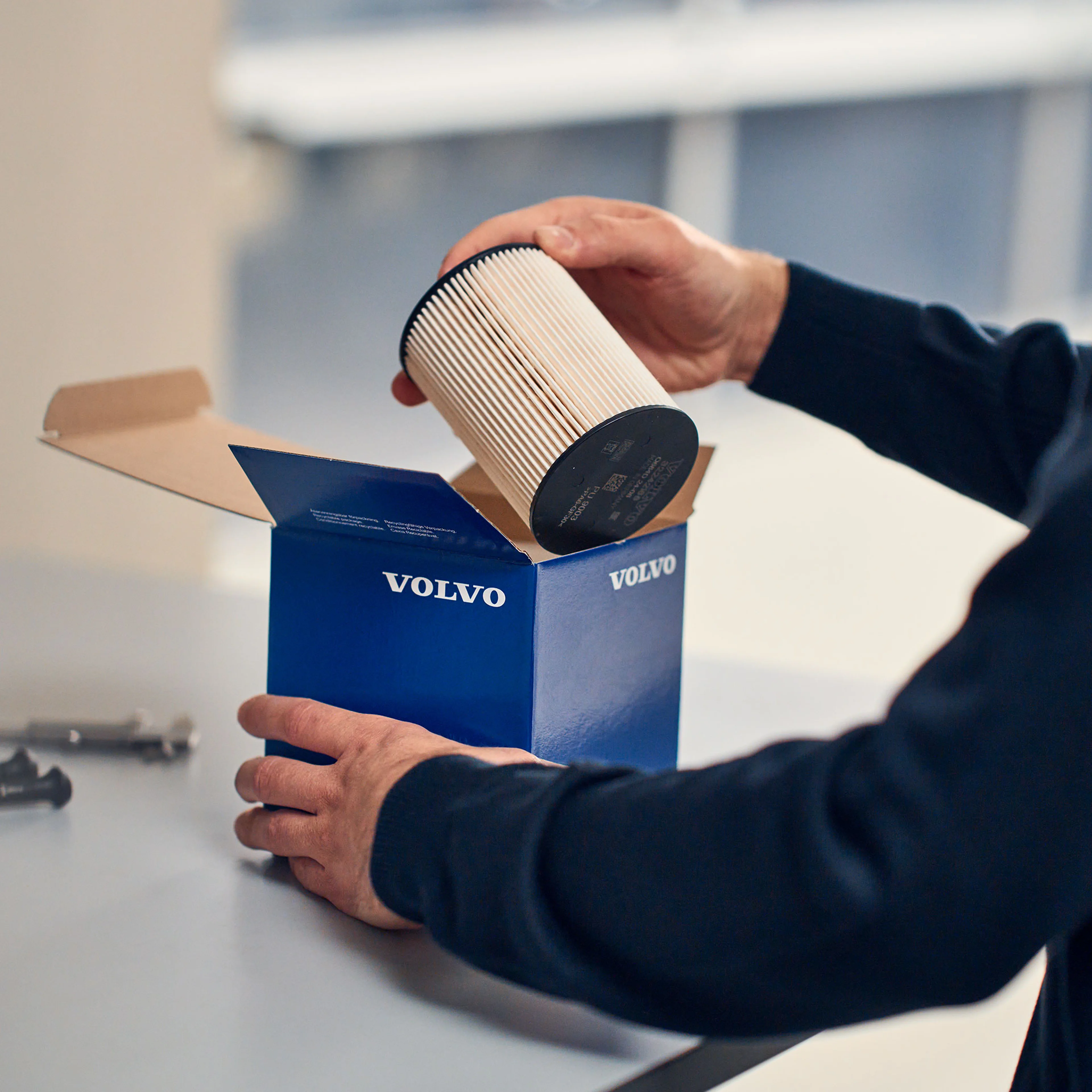 Volvo Omamekaanikon kädessä pakkauksesta otettu Volvo Alkuperäinen varaosa suodatin.