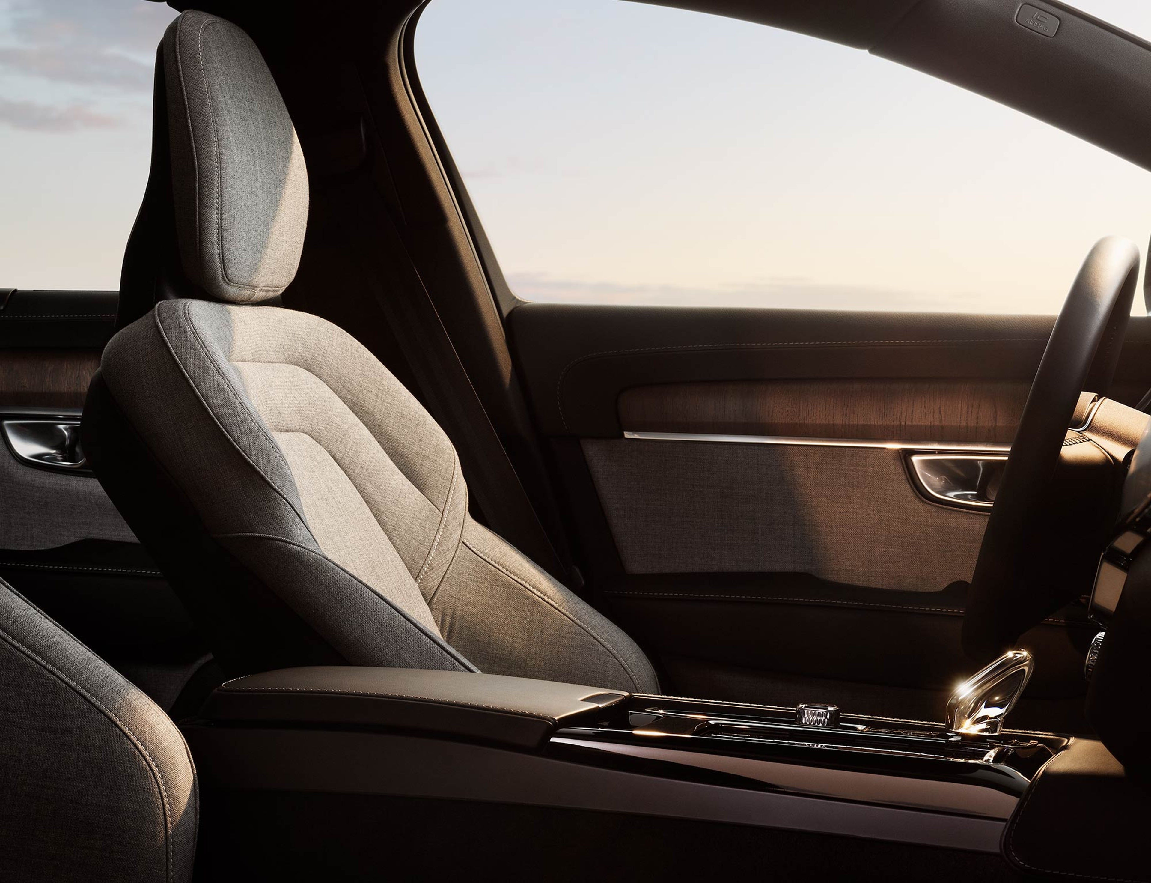 Gros plan de l'intérieur d'une voiture, mettant l'accent sur le revêtement en tissu du siège et les détails en bois.