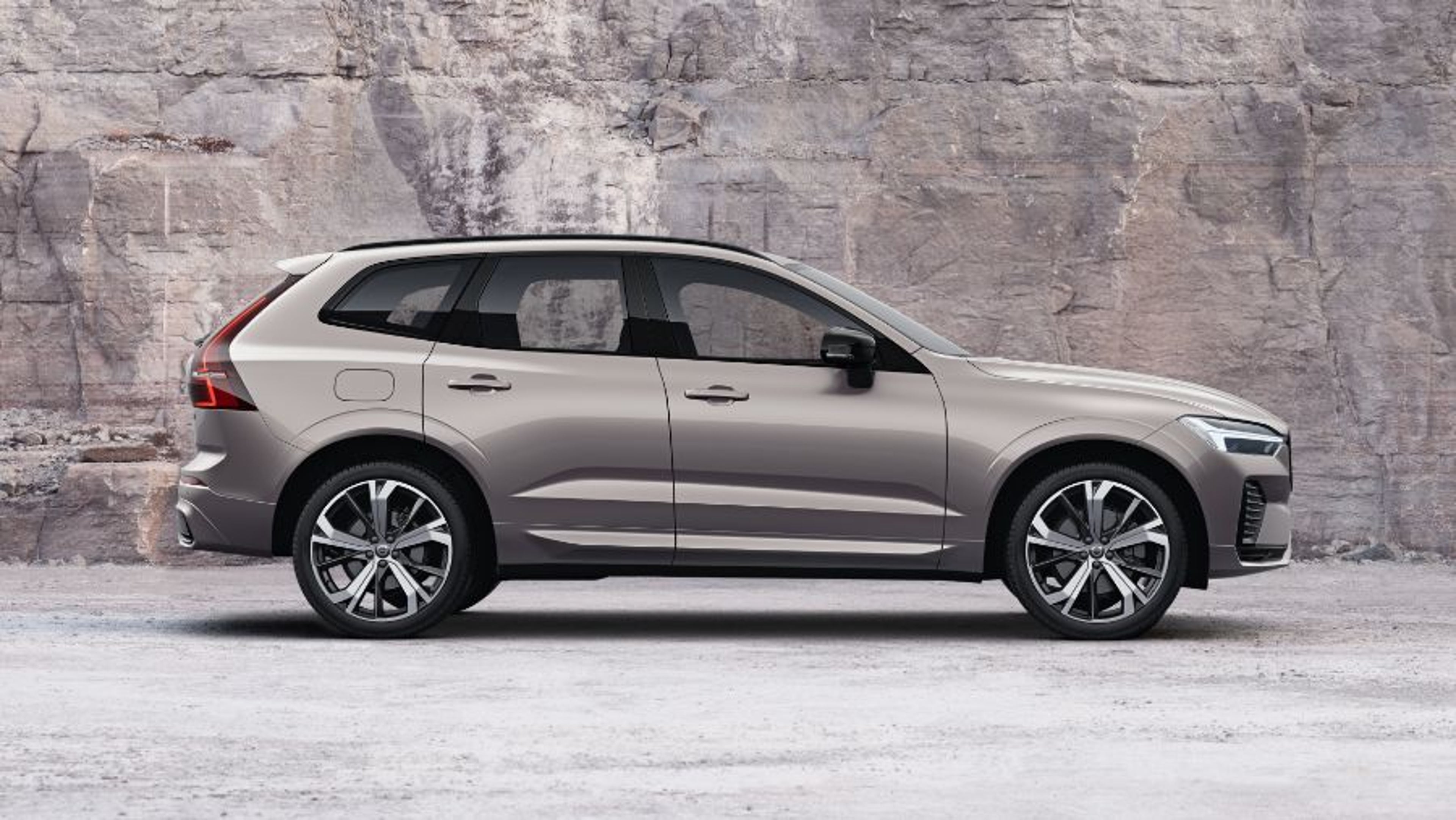 Srebrni Volvo XC60 parkiran pred kamnitim zidom.