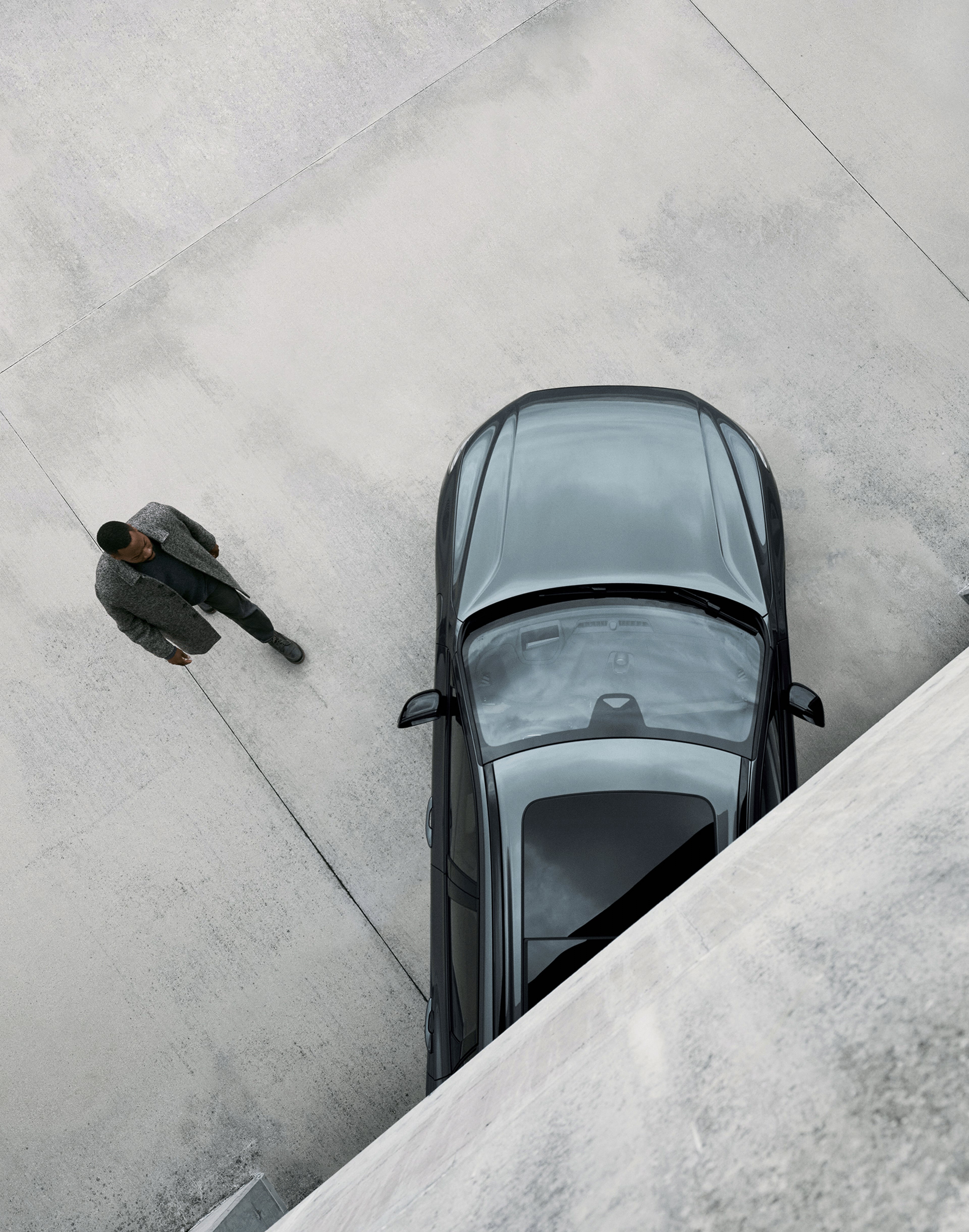 Ein Mann läuft auf einen Volvo XC60 zu.