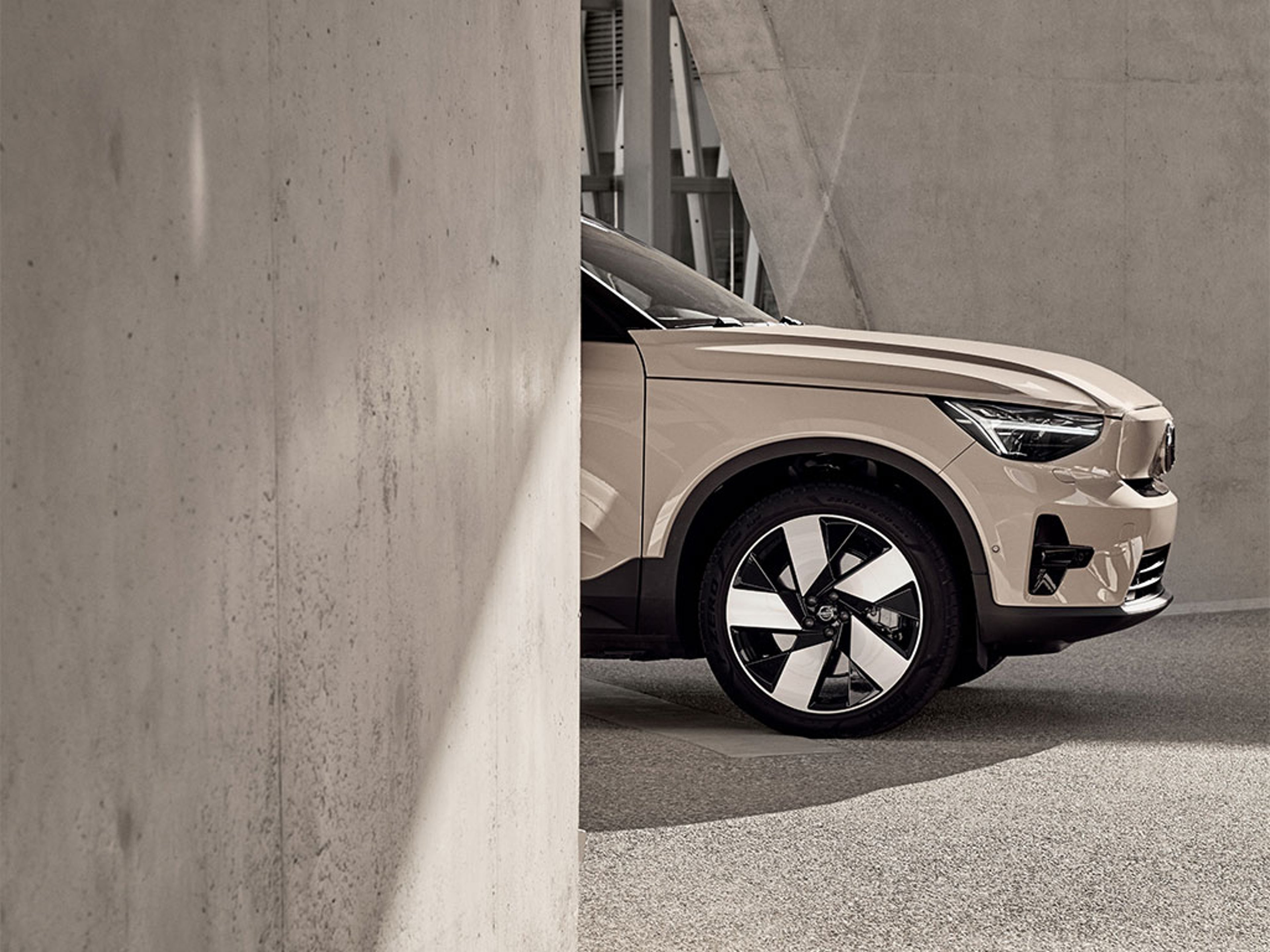 Vue tronquée d’un EX40 montrant l’avant du SUV dans un décor urbain moderne.