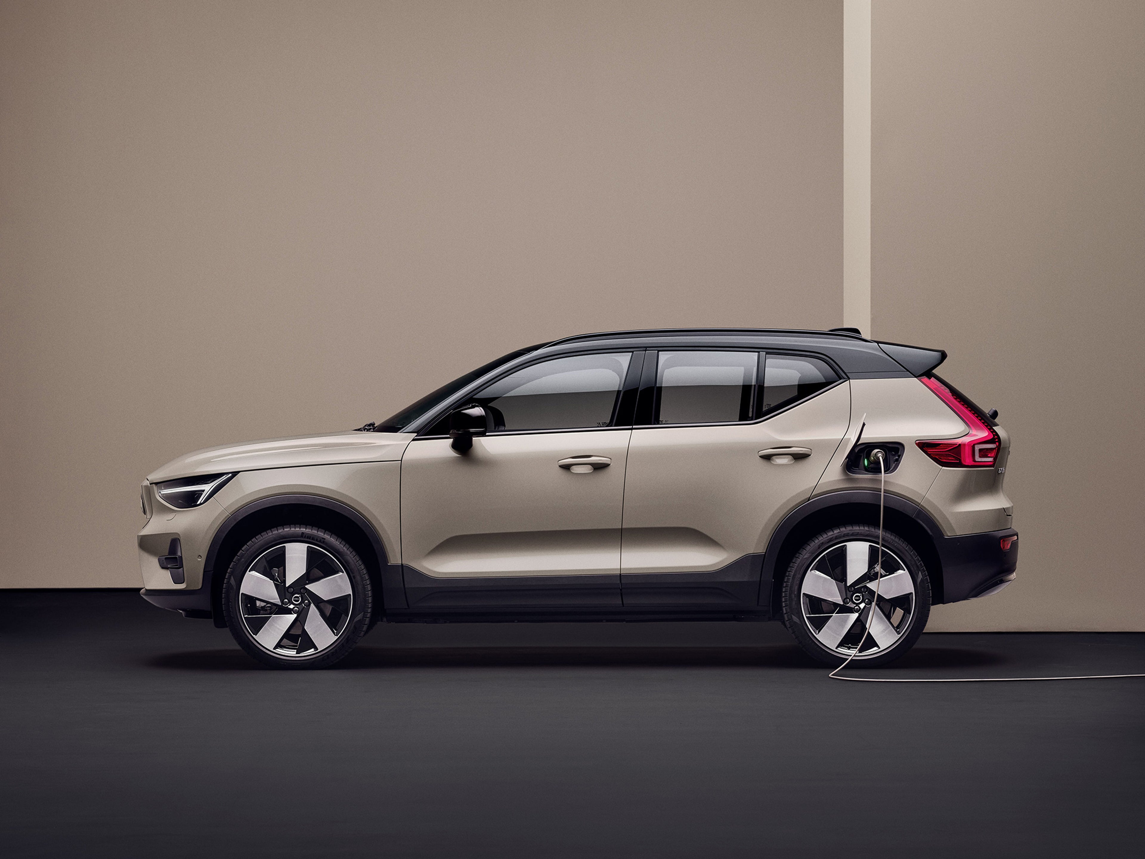 Sand Dune -värinen Volvo EX40 kytkettynä lataukseen.