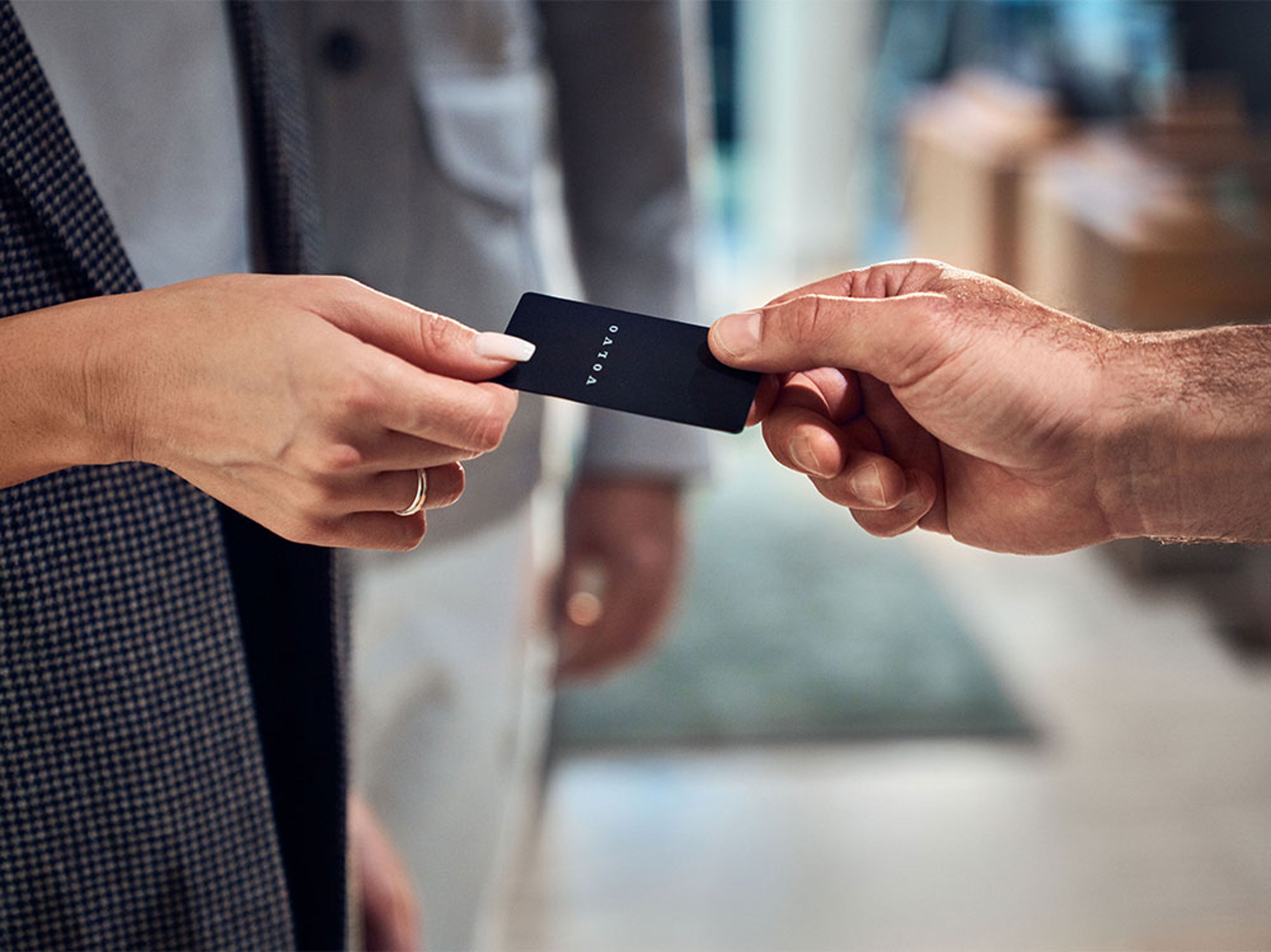Deux personnes se passent une carte-clé de Volvo.