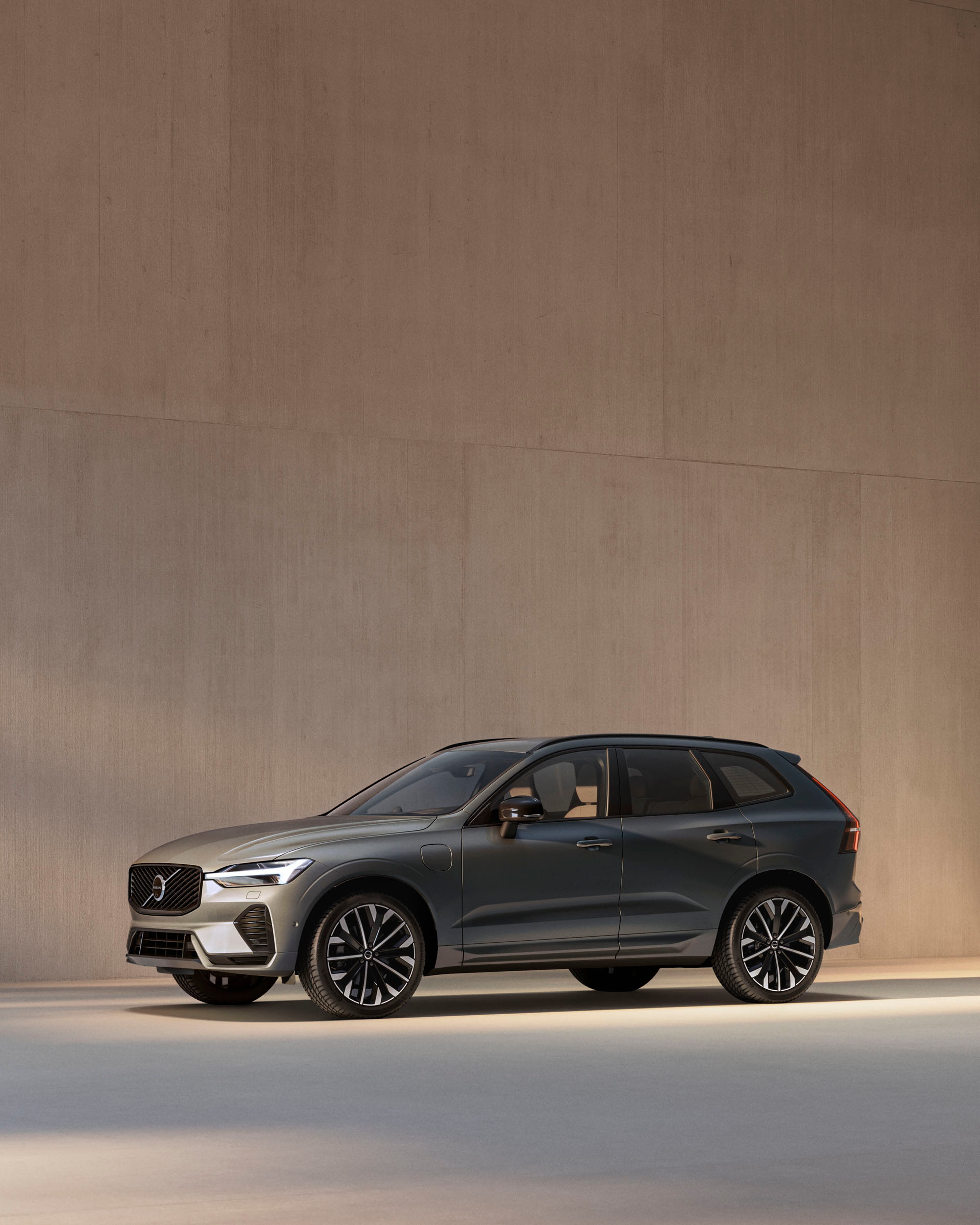 Volvo XC60 híbrido enchufable vista lateral frontal destacando sus llantas y sus luces LED