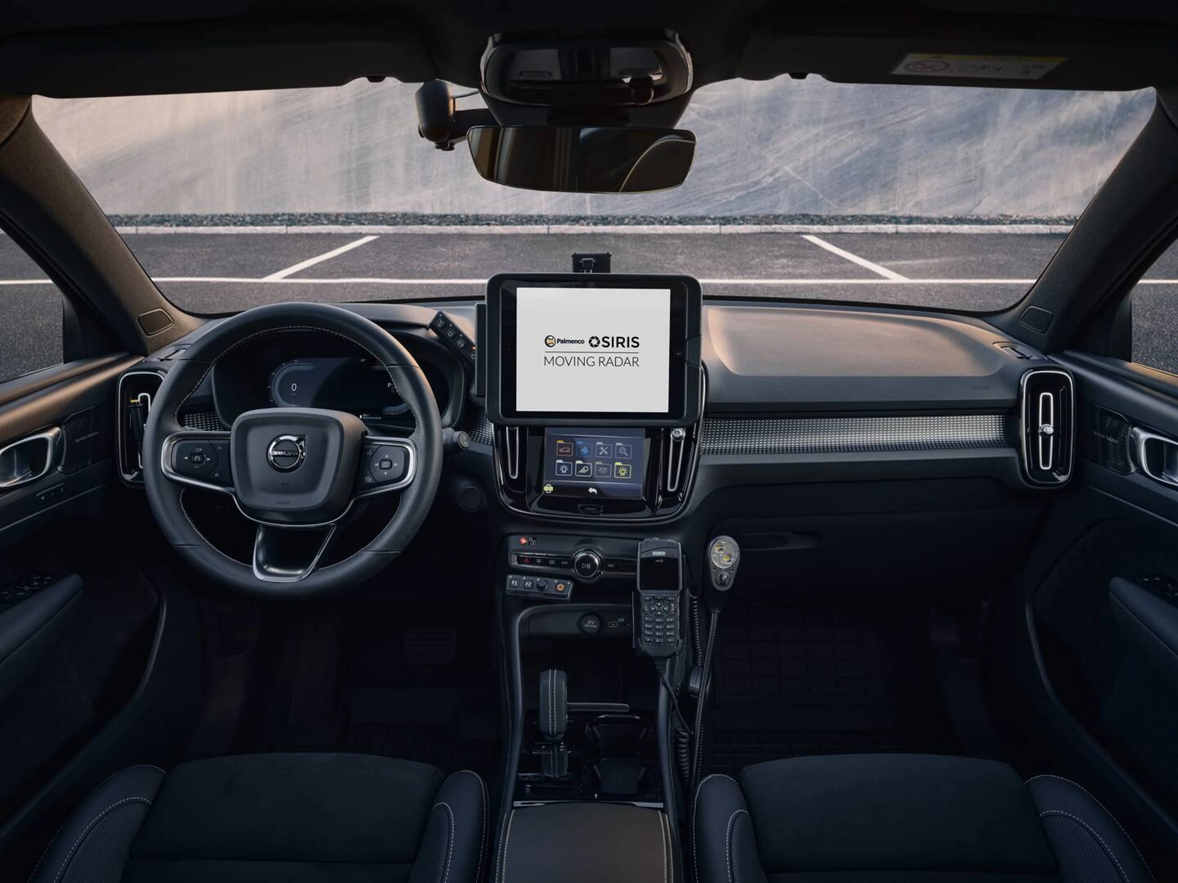 Førerpladsen i en Volvo politibil med digital instrumentering og en midterkonsolskærm, der viser teksten 'OSIRIS MOVING RADAR', som indikerer aktivt radarudstyr til fartmåling.
