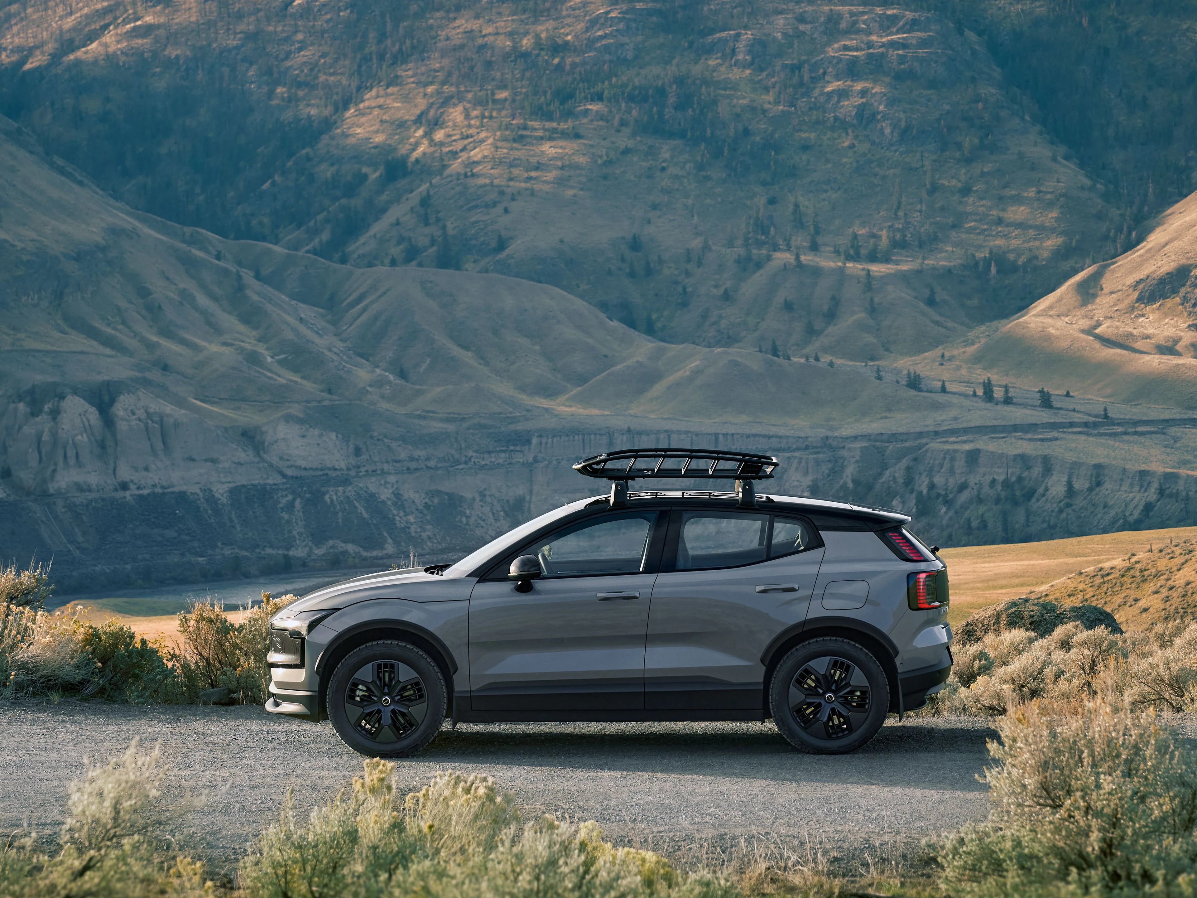 Ein anthrazitfarbener Volvo EX30 Cross Country steht vor einem Canyon.