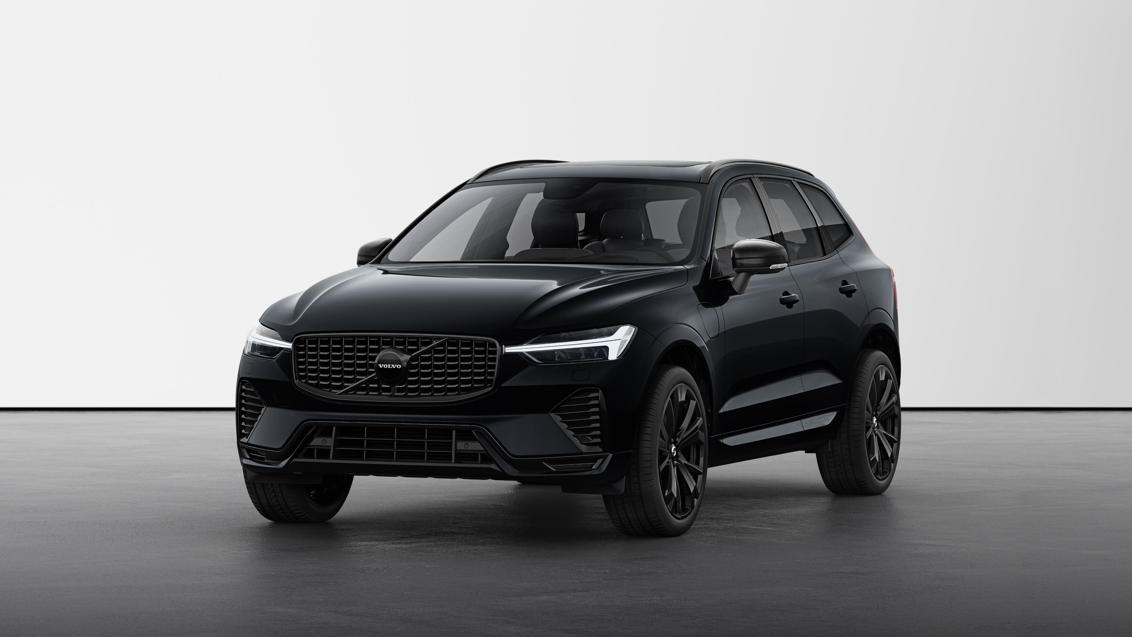 Volvo XC60 Black Edition au design épuré et phares modernes, dans un décor de studio minimaliste