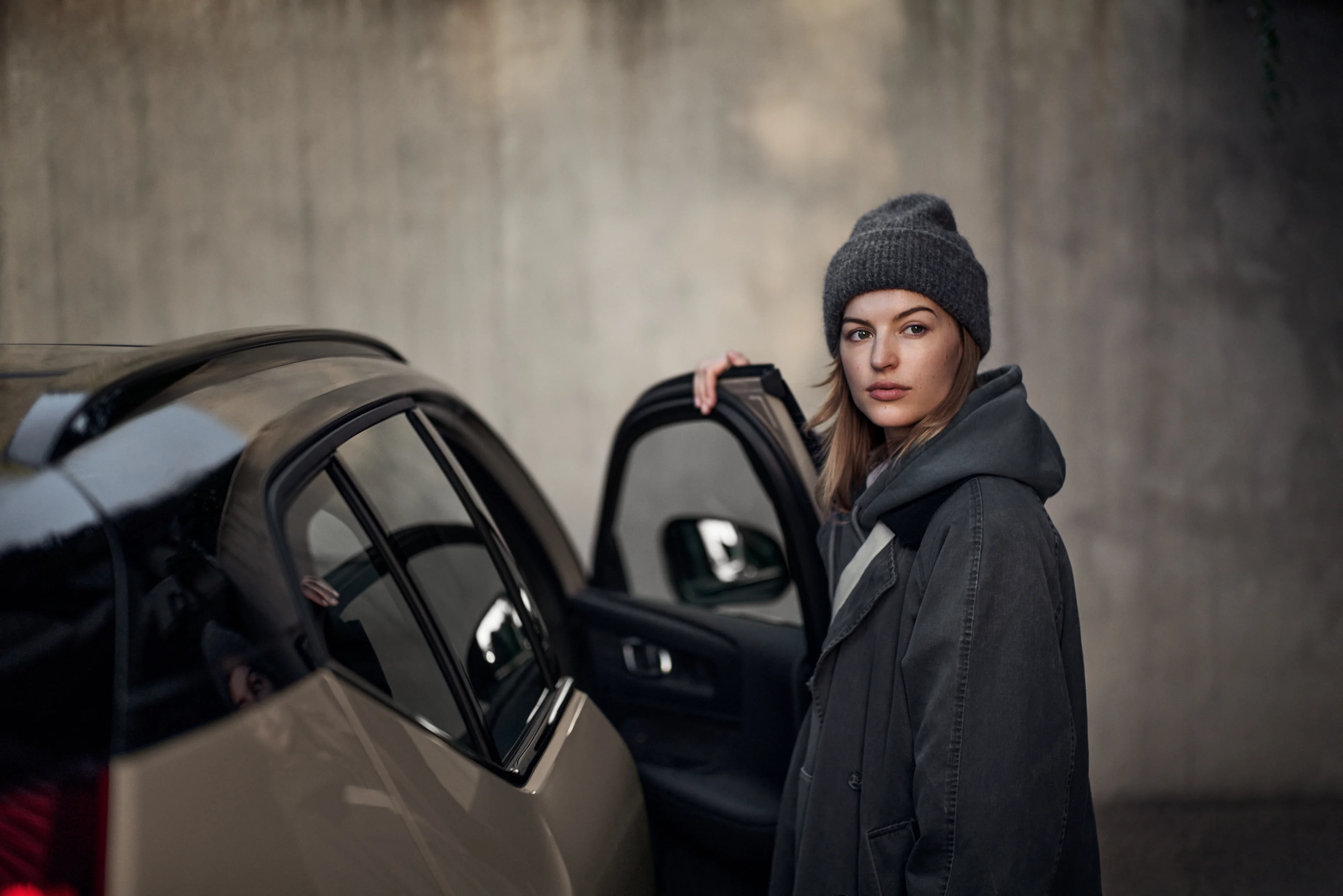 Femme à coté d'un Volvo EX40 avec la porte ouverte