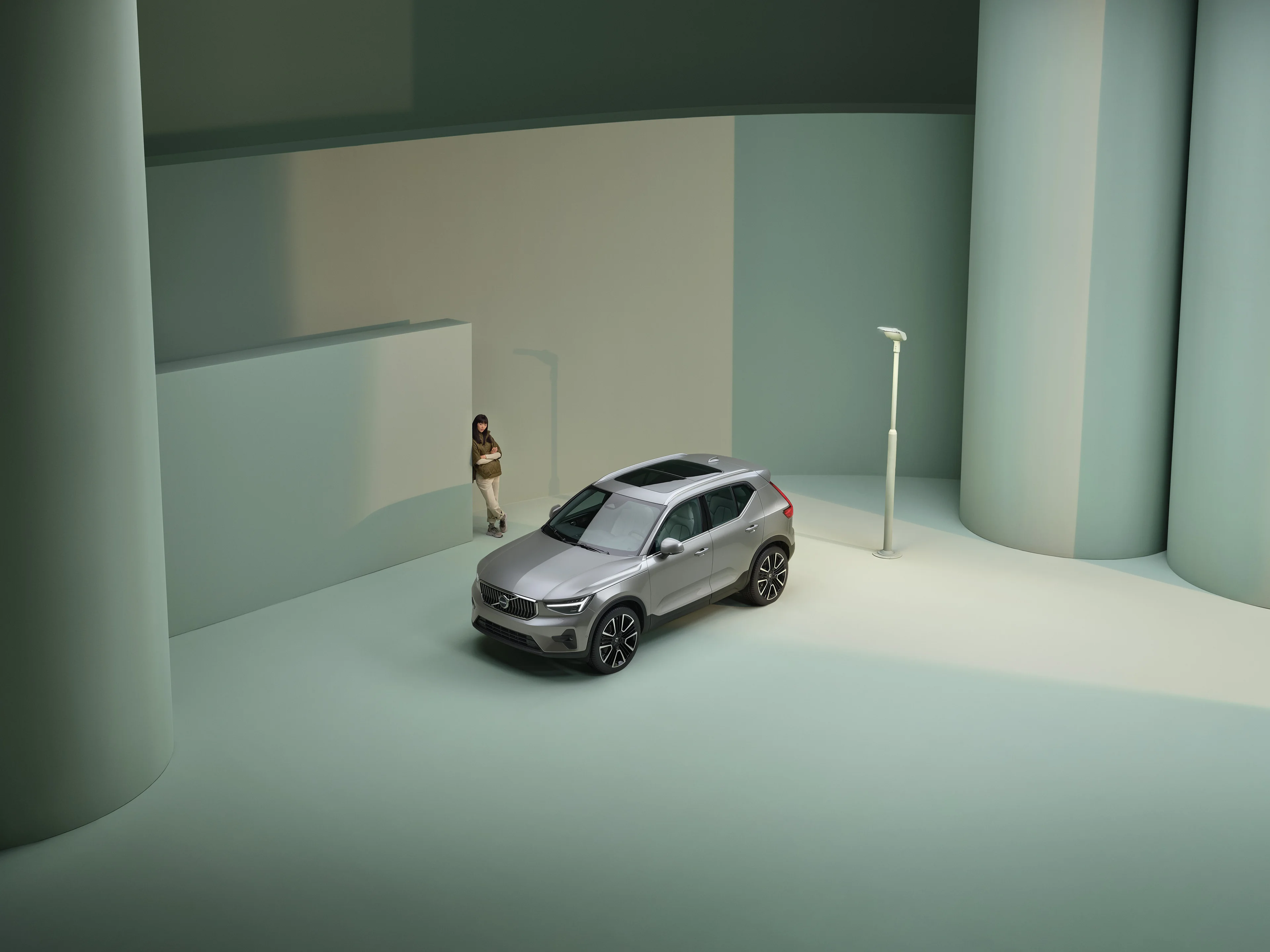 Volvo XC40 stojące przodobokiem na tle zielonej architektury