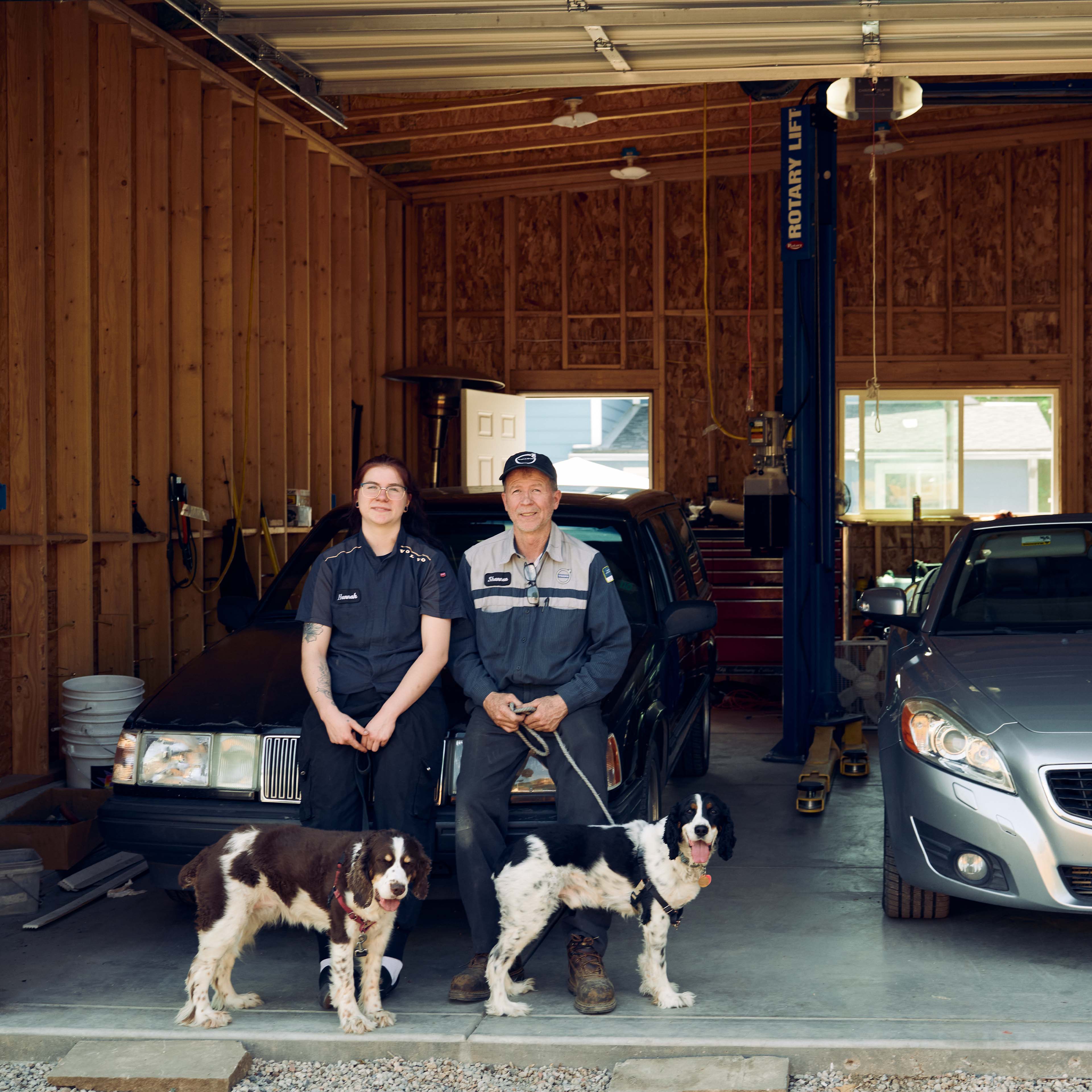 People standing near Volvo car with dog