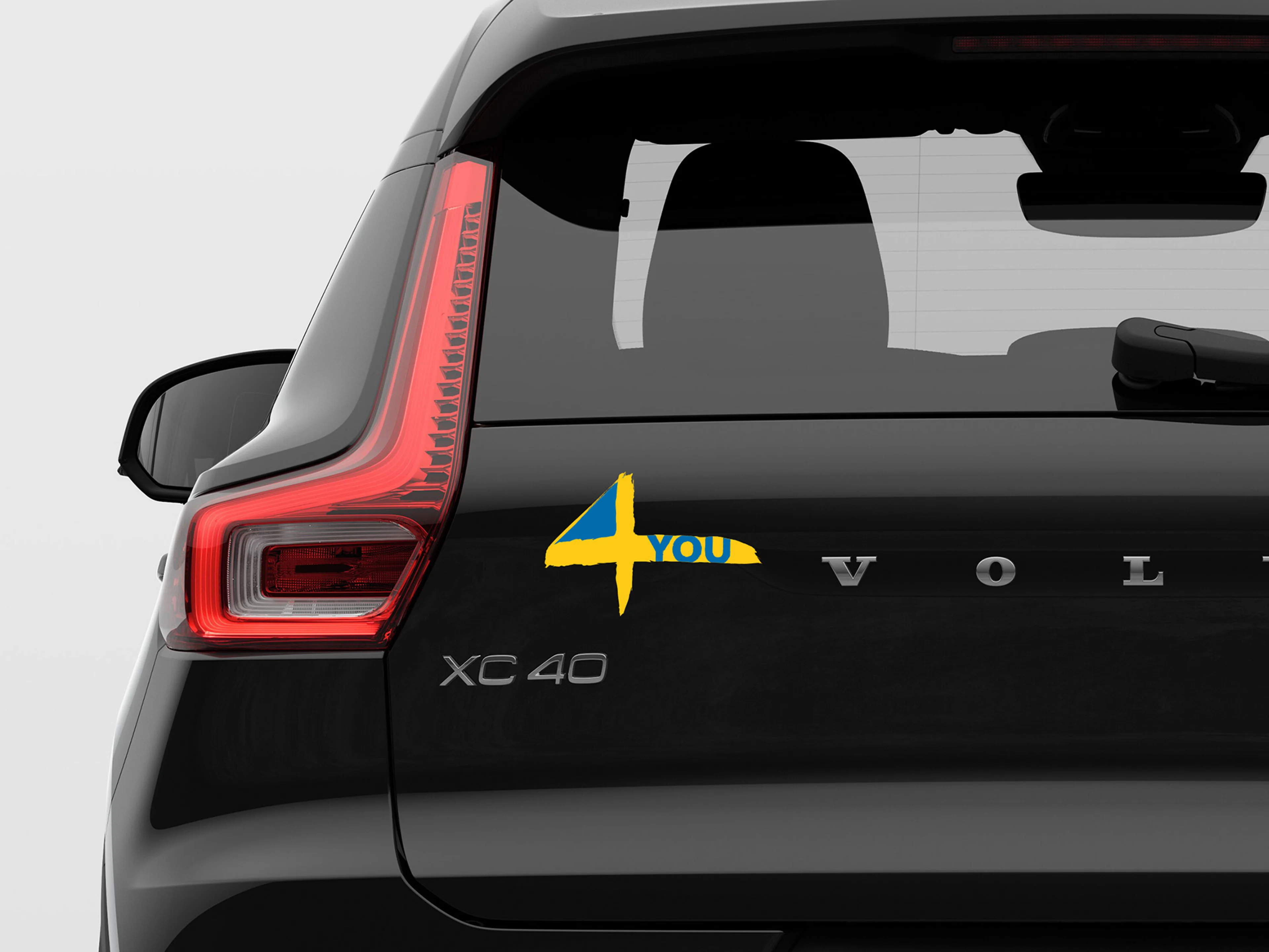 Ein schwarzer XC40 von hinten mit Fokus auf den Aufkleber "4 You" der gleichzeitig die schwedische Flagge abbildet.