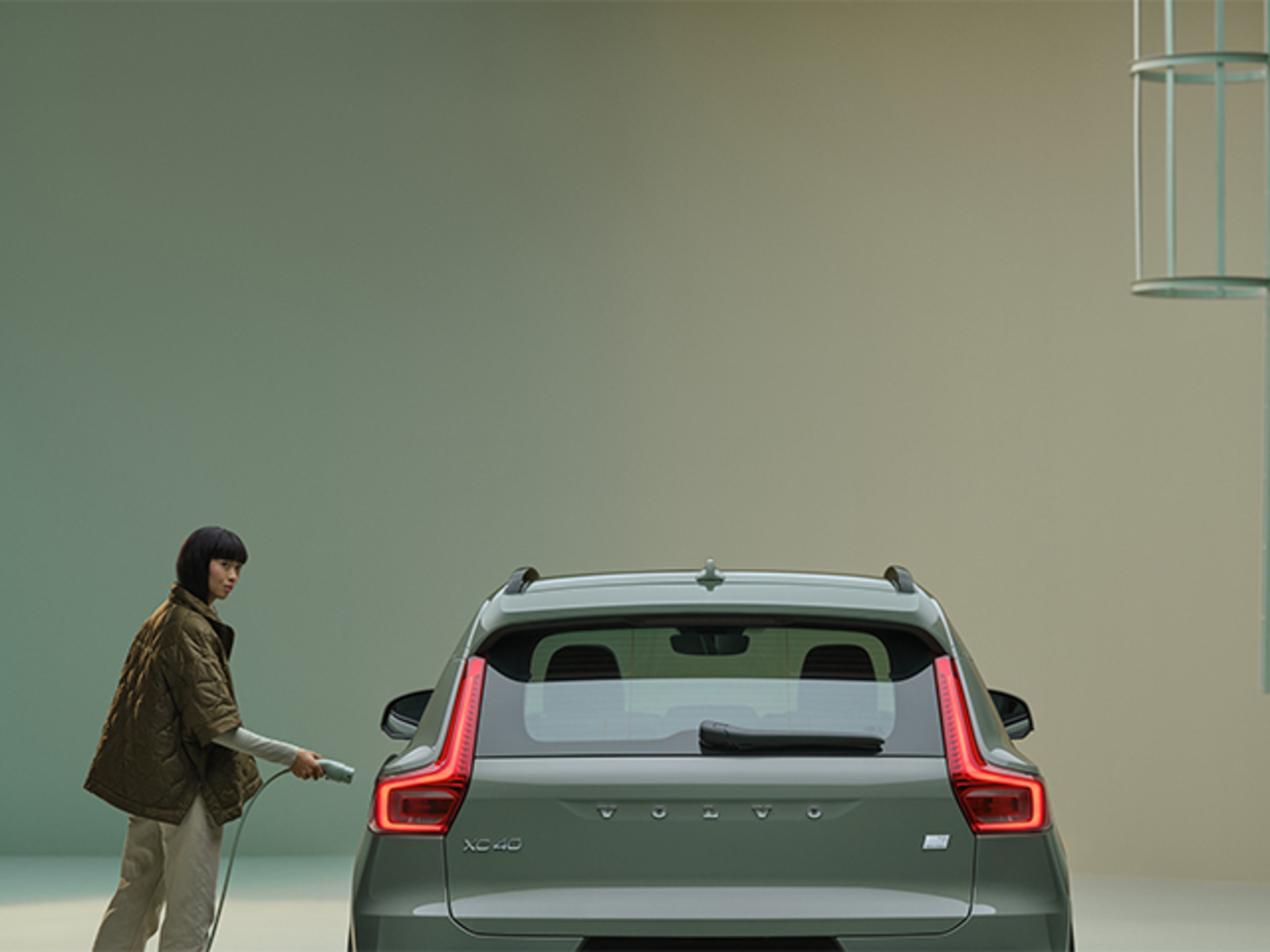 Kvinna bredvid en grön Volvo XC40 Recharge