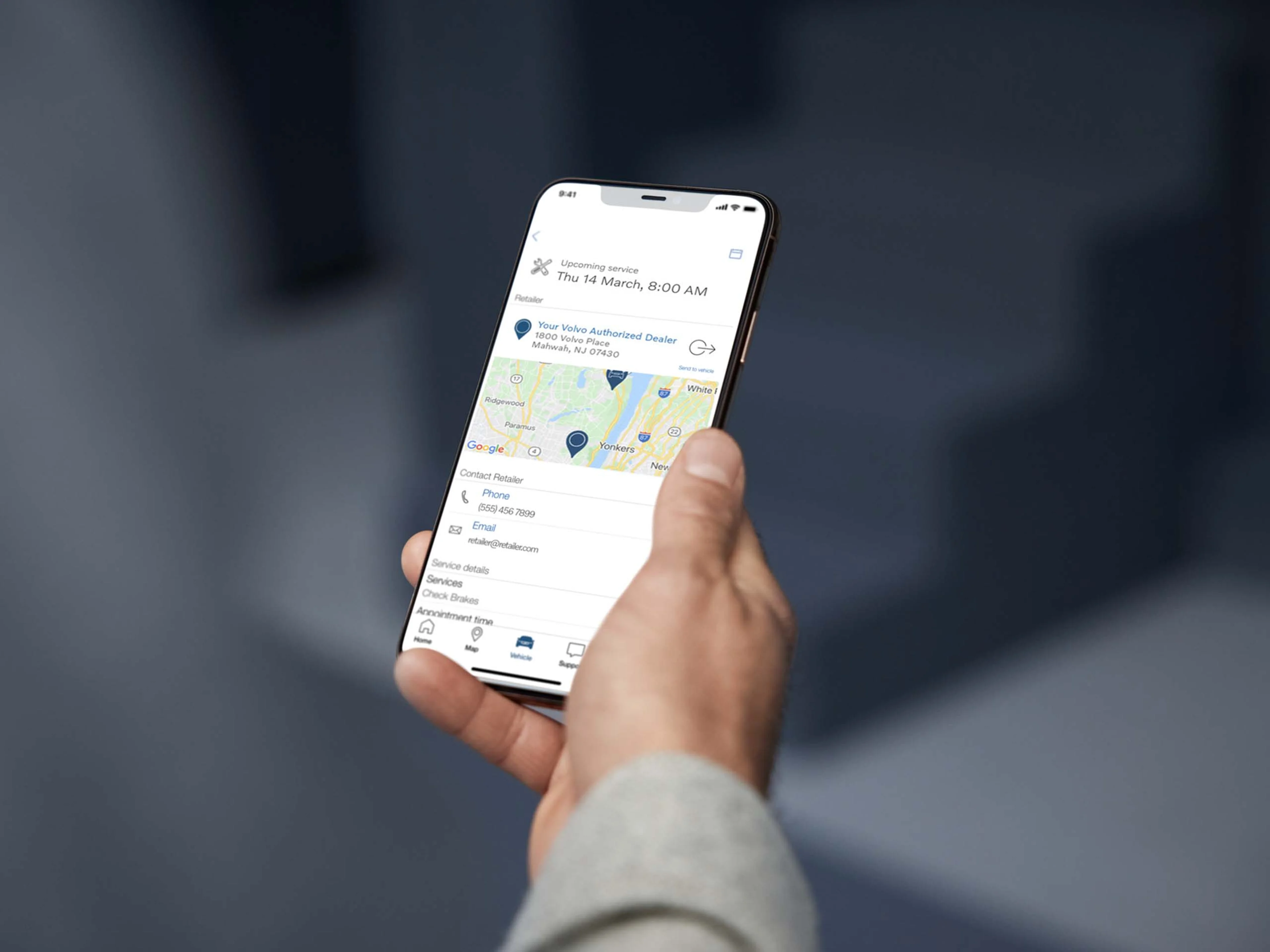 Persoon met telefoon in hand. Op de telefoon is de Volvo Cars app te zien.
