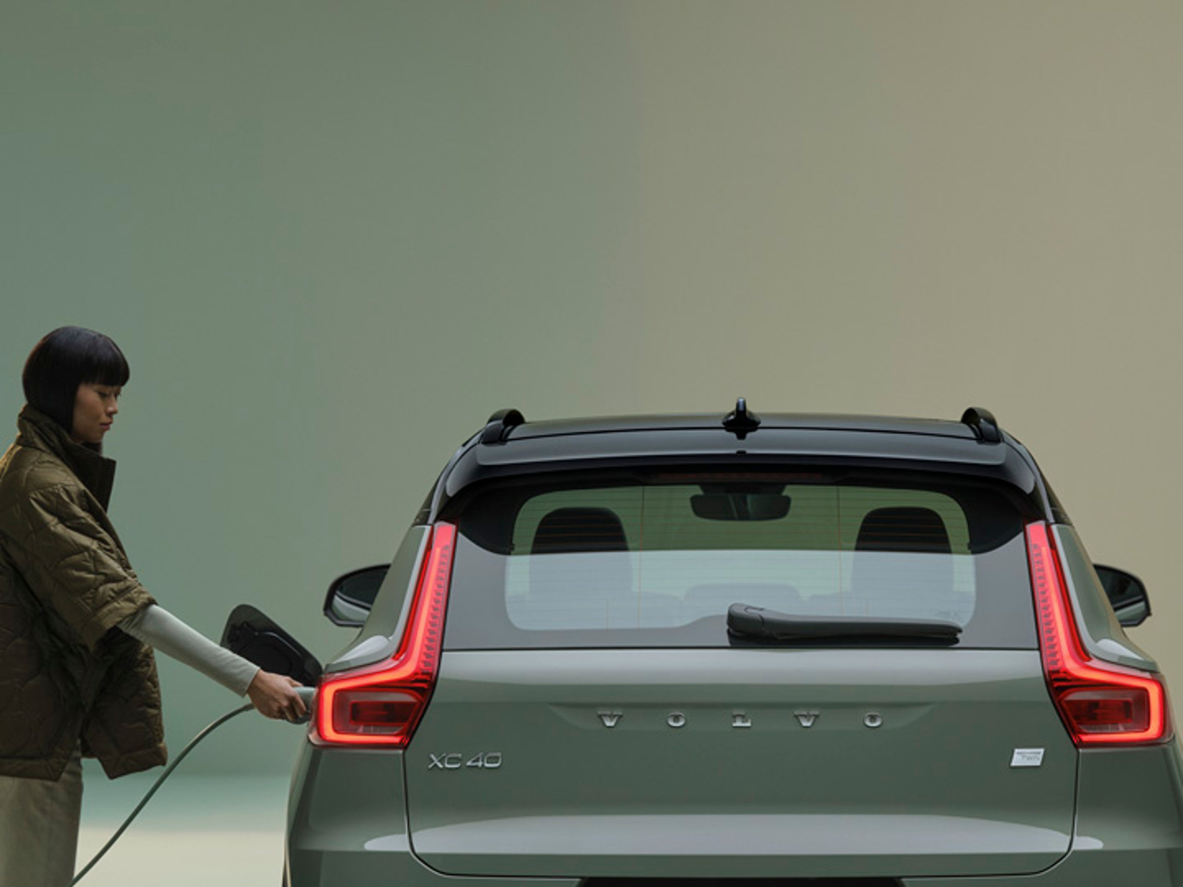 Mujer cargando un Volvo XC40 eléctrico puro