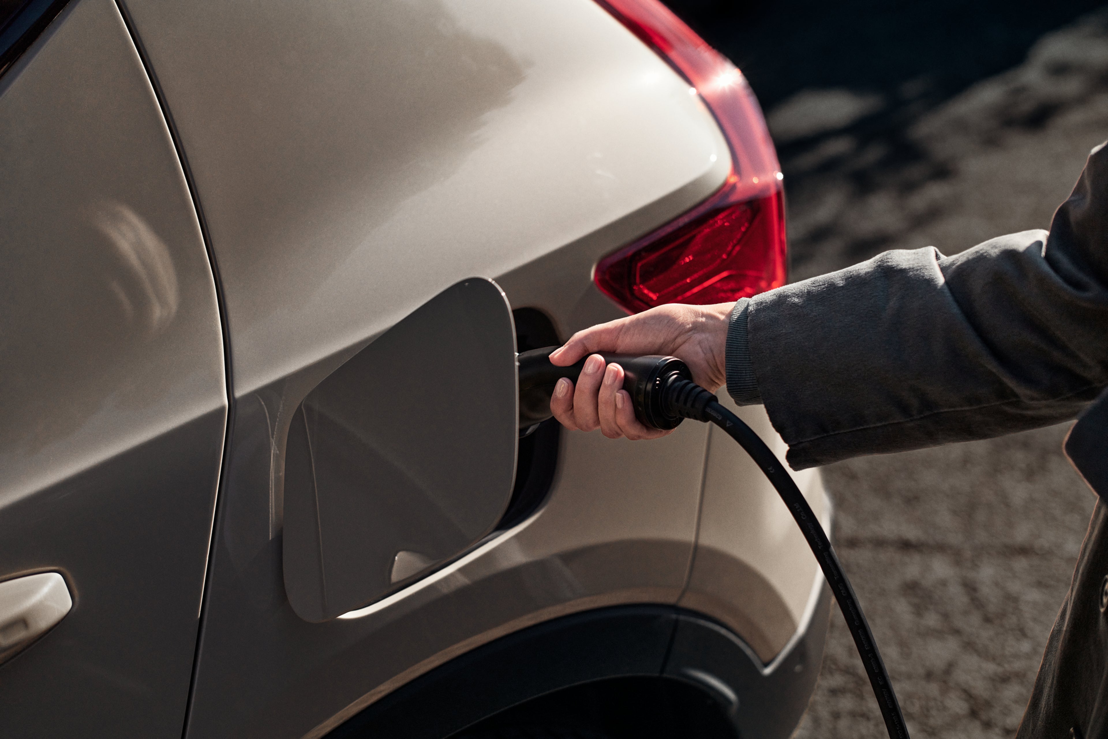 Personne branchant un câble de recharge à un Volvo EX40