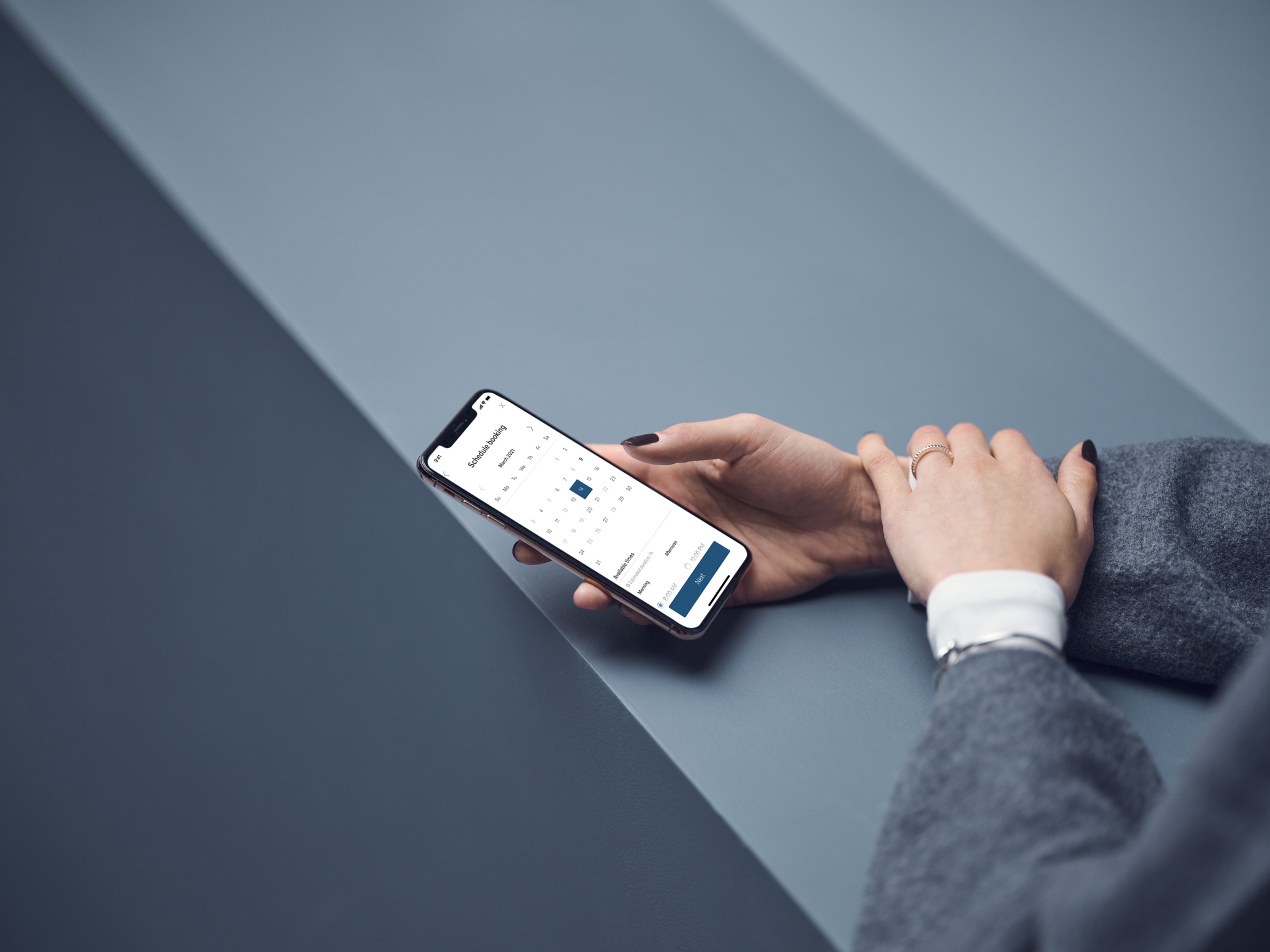 En som holder en telefon med Volvo Cars-appen