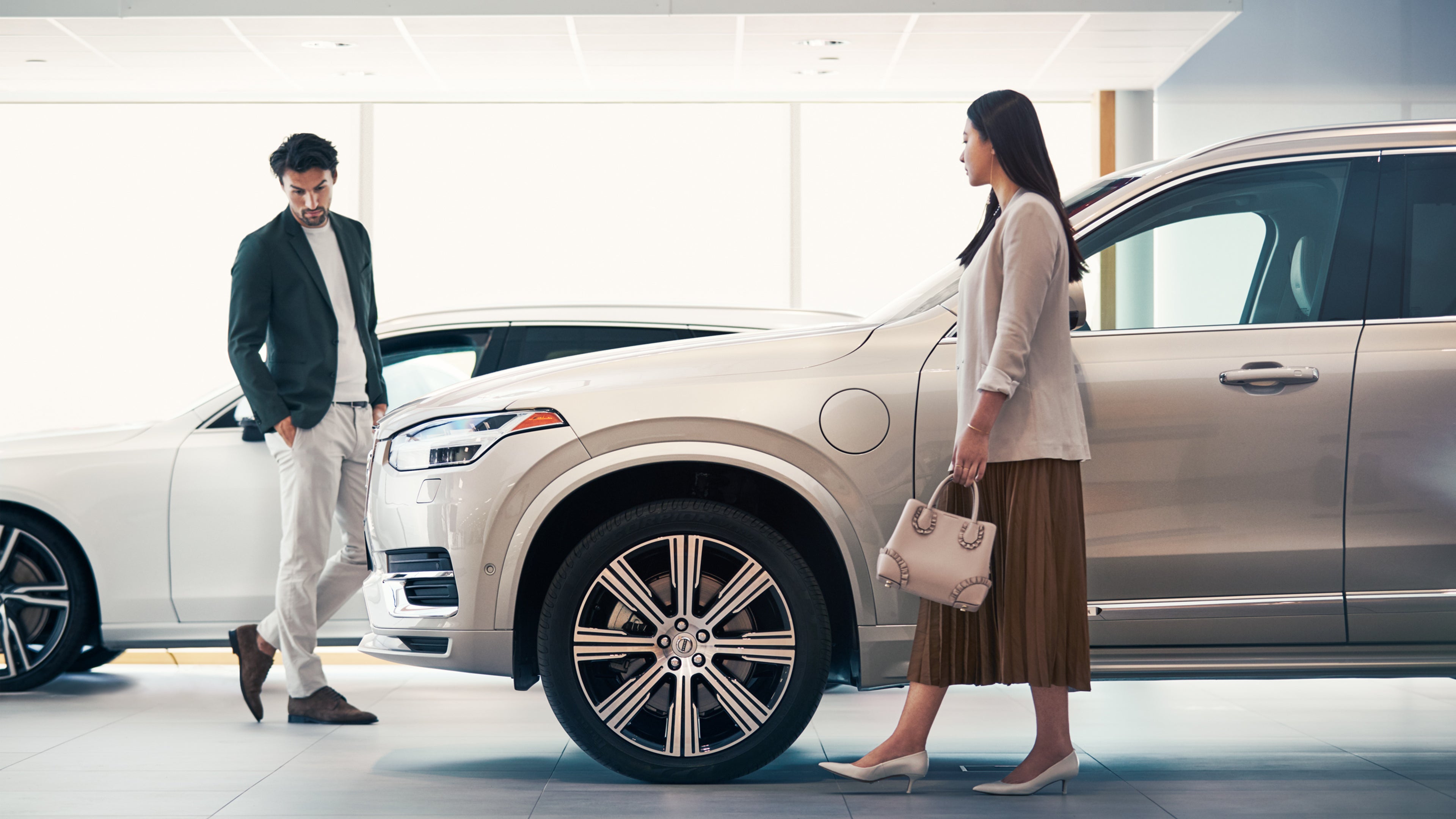 Une femme et un homme à coté d'une Volvo