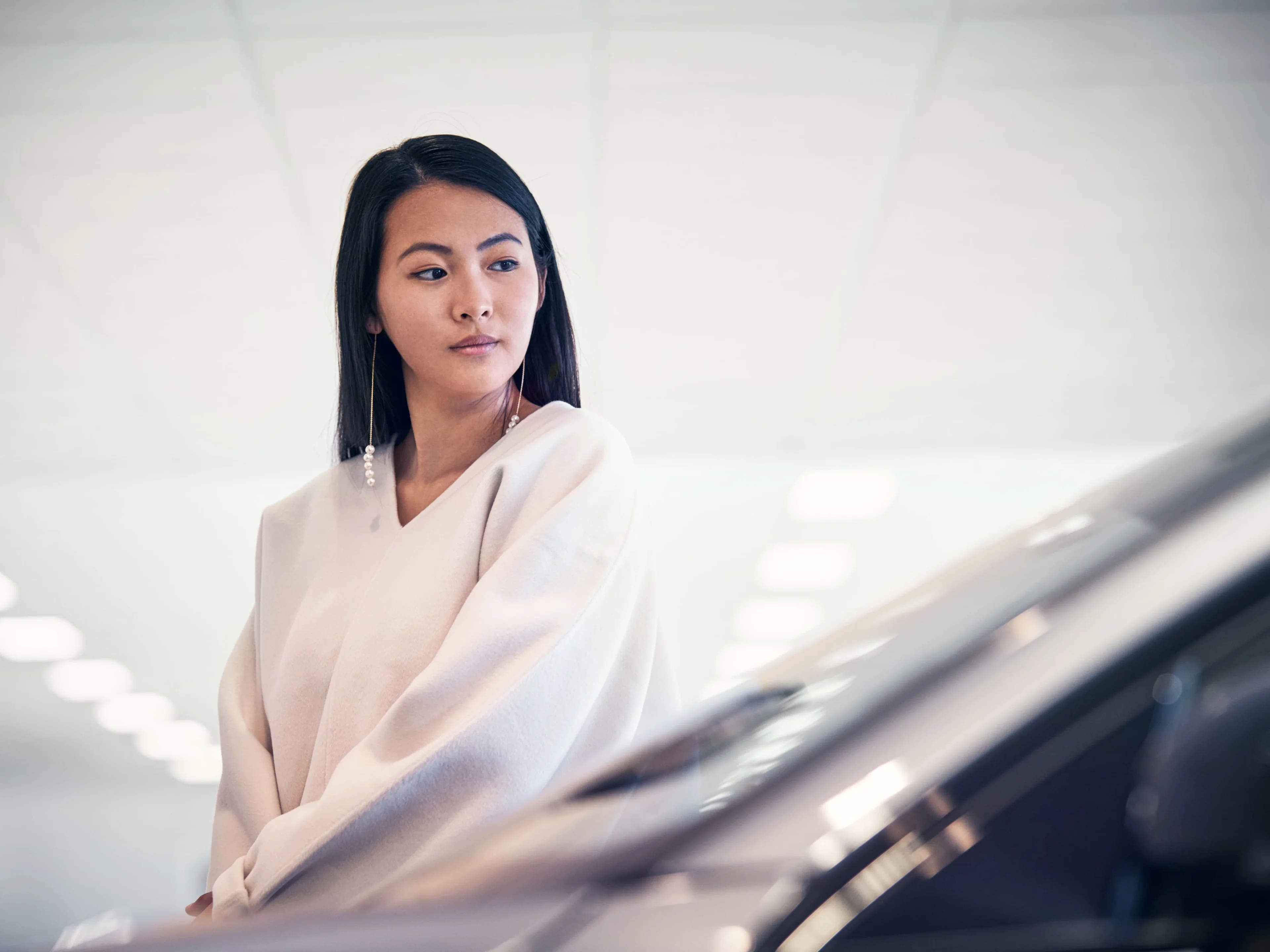 Gros plan d’une femme regardant l’avant d’une Volvo dans une salle d’exposition.