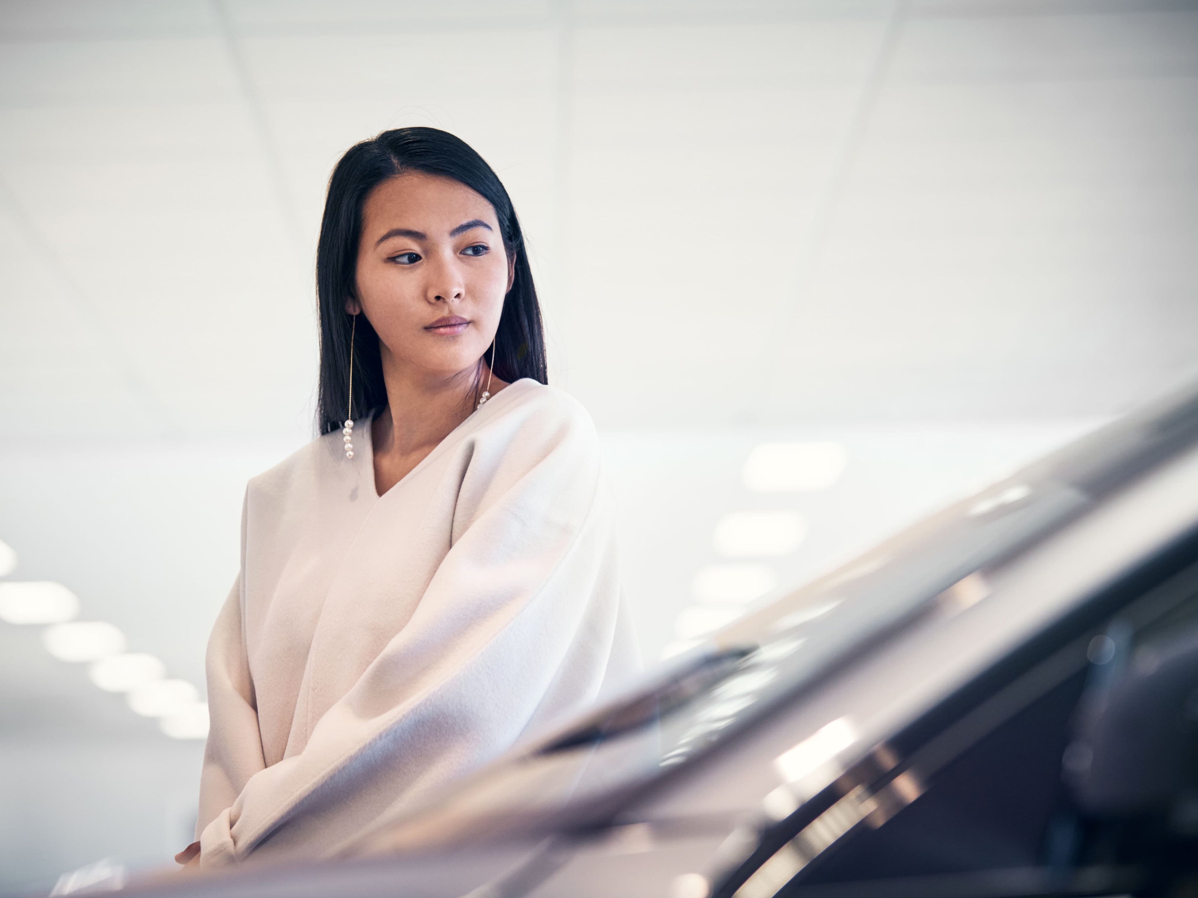 Close-up van een vrouw die de voorkant van een Volvo bekijkt in een toonzaal.