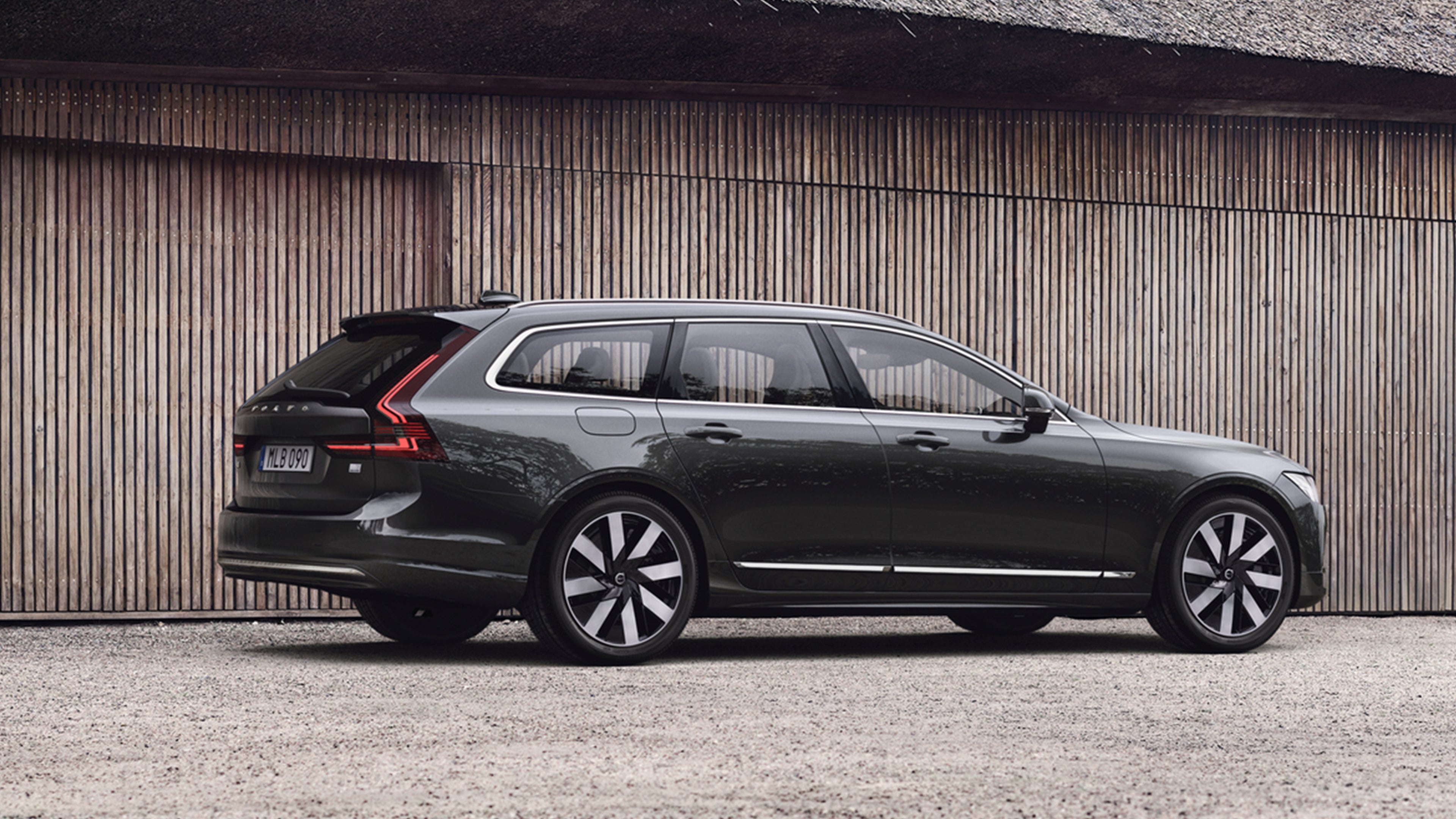 Platinum Grey -värinen Volvo V90 lataushybridi pysäköitynä pihaan.