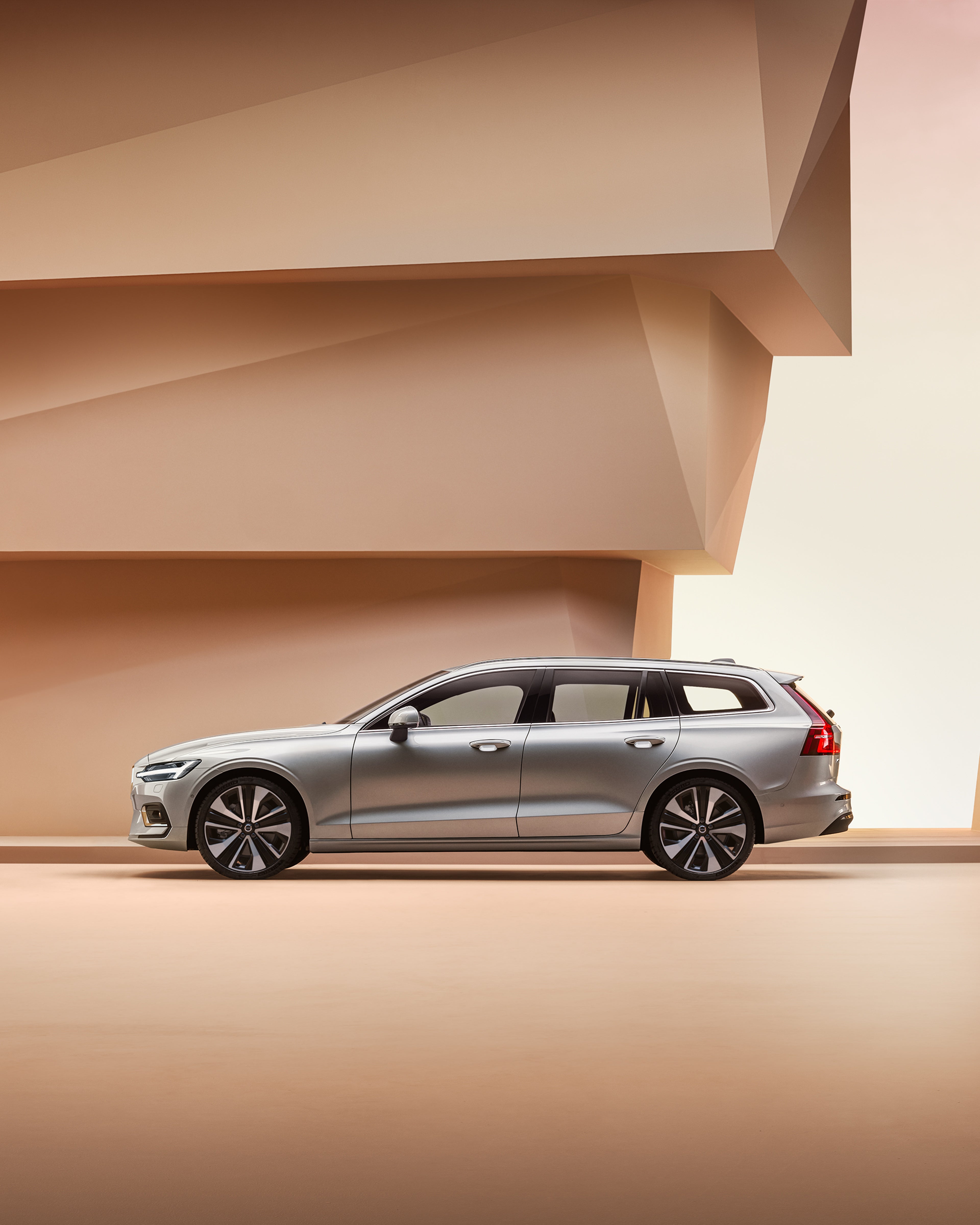 Silvrig Volvo V60 från sidan i ljus studiomiljö