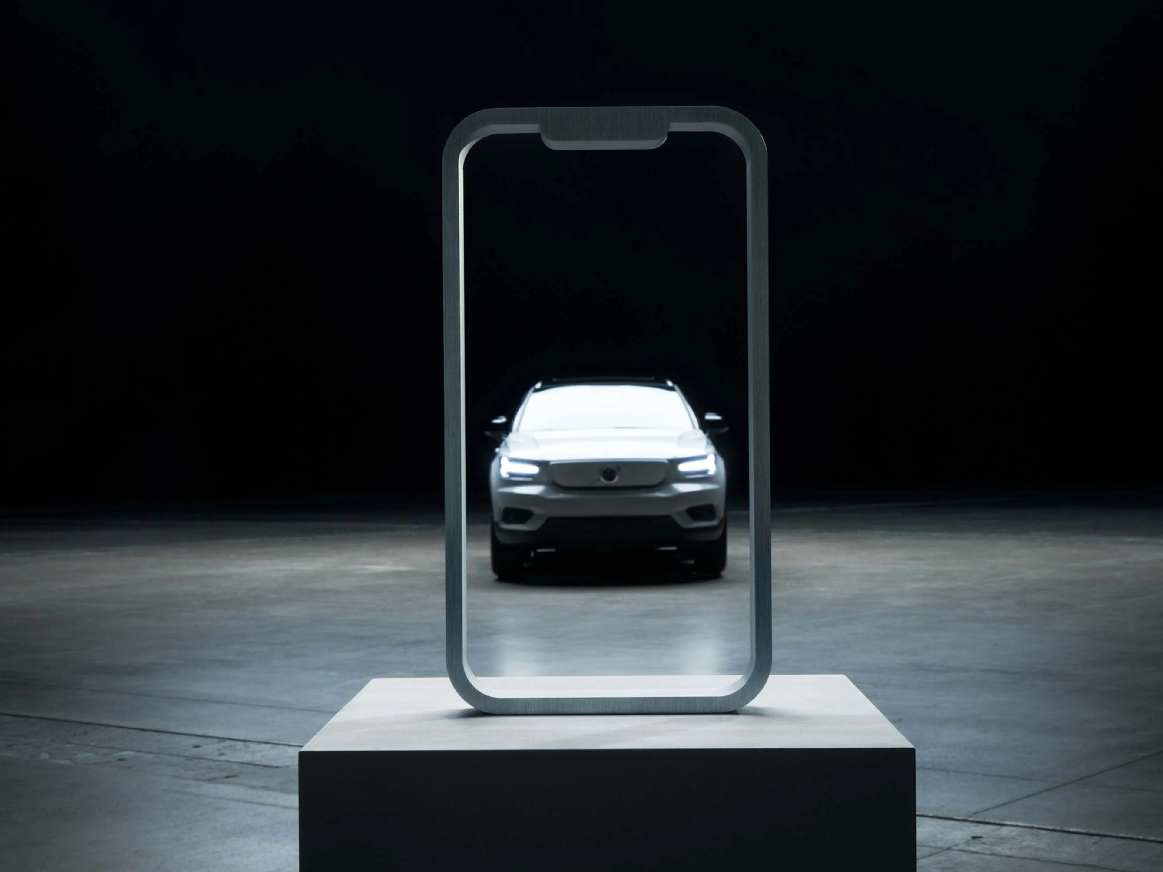 Doorzichtige Iphone waardoor een Volvo is te zien.