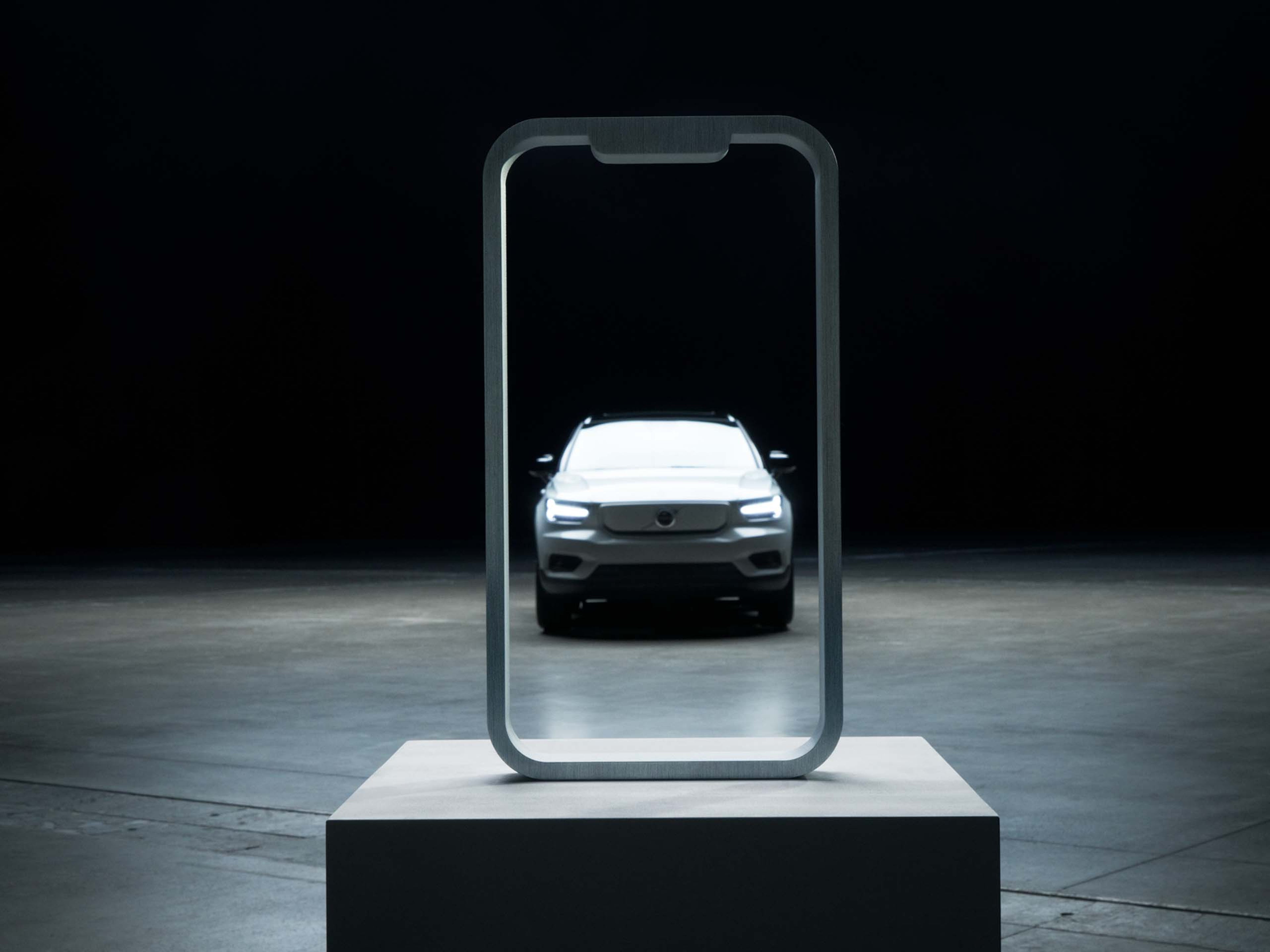 Doorzichtige Iphone waardoor een Volvo is te zien.