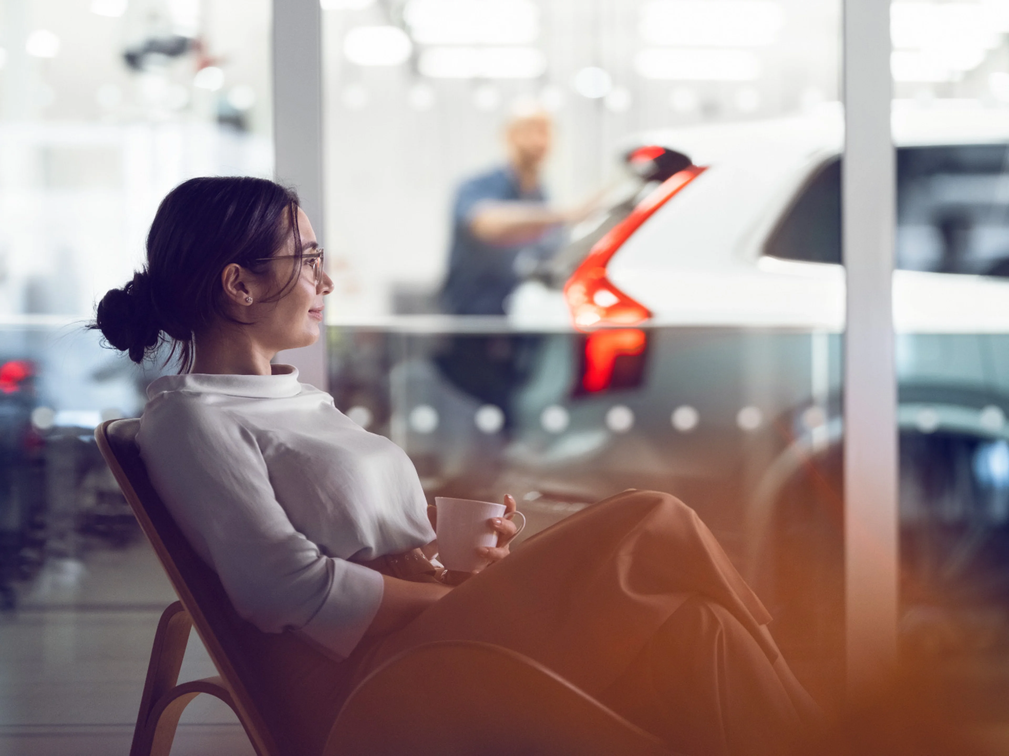 Une femme assise dans un fauteuil dans le salon Volvo.