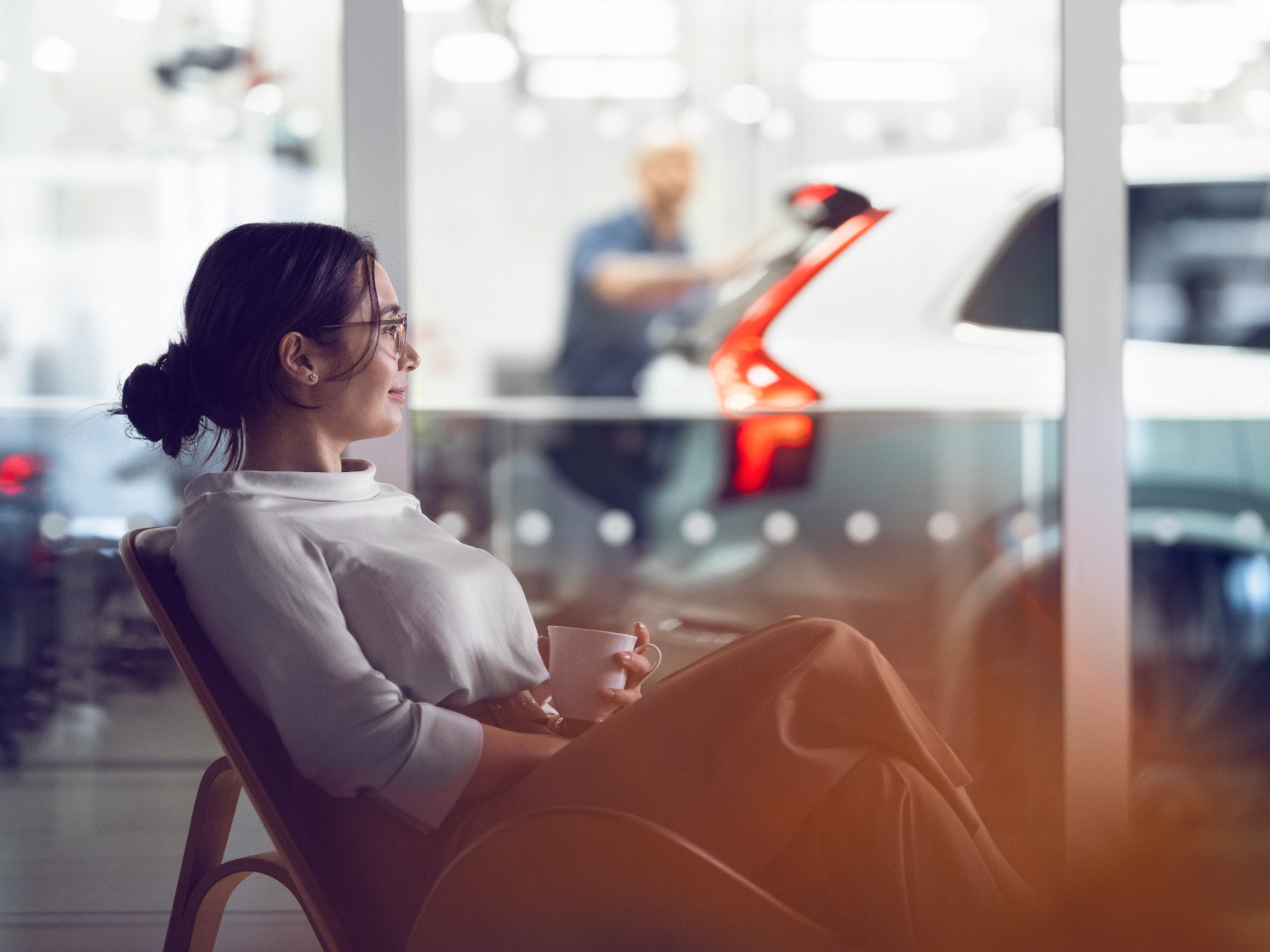 Une femme assise dans un fauteuil dans le salon Volvo.